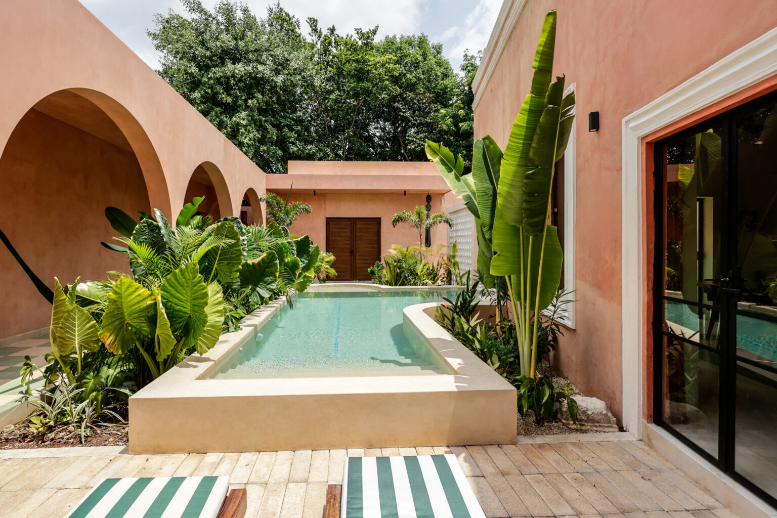 Cozy courtyard with a small pool and lush greenery.