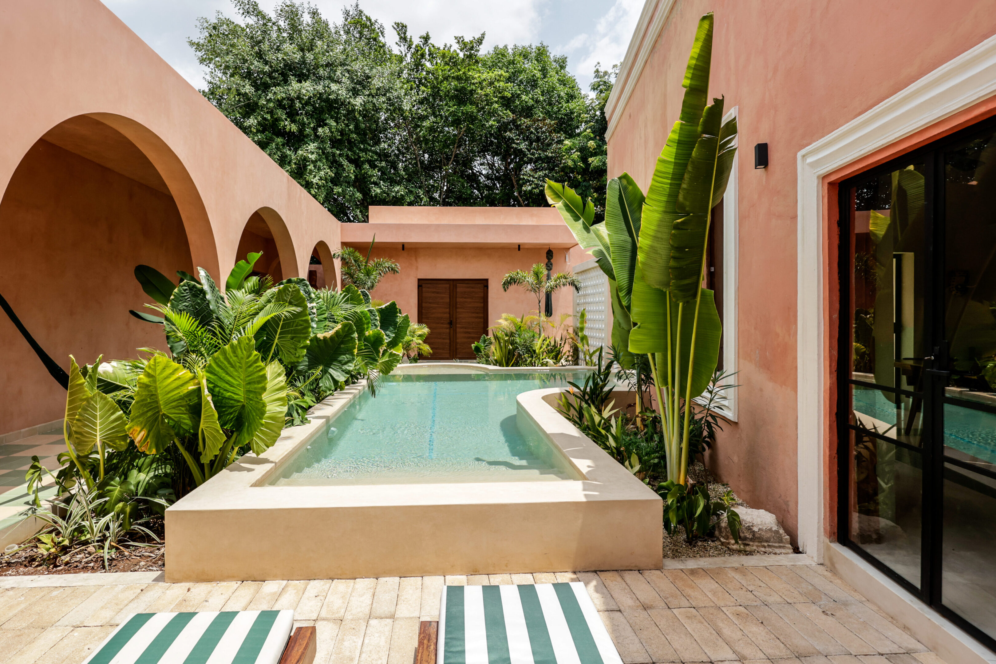 Cozy courtyard with a small pool and lush greenery.
