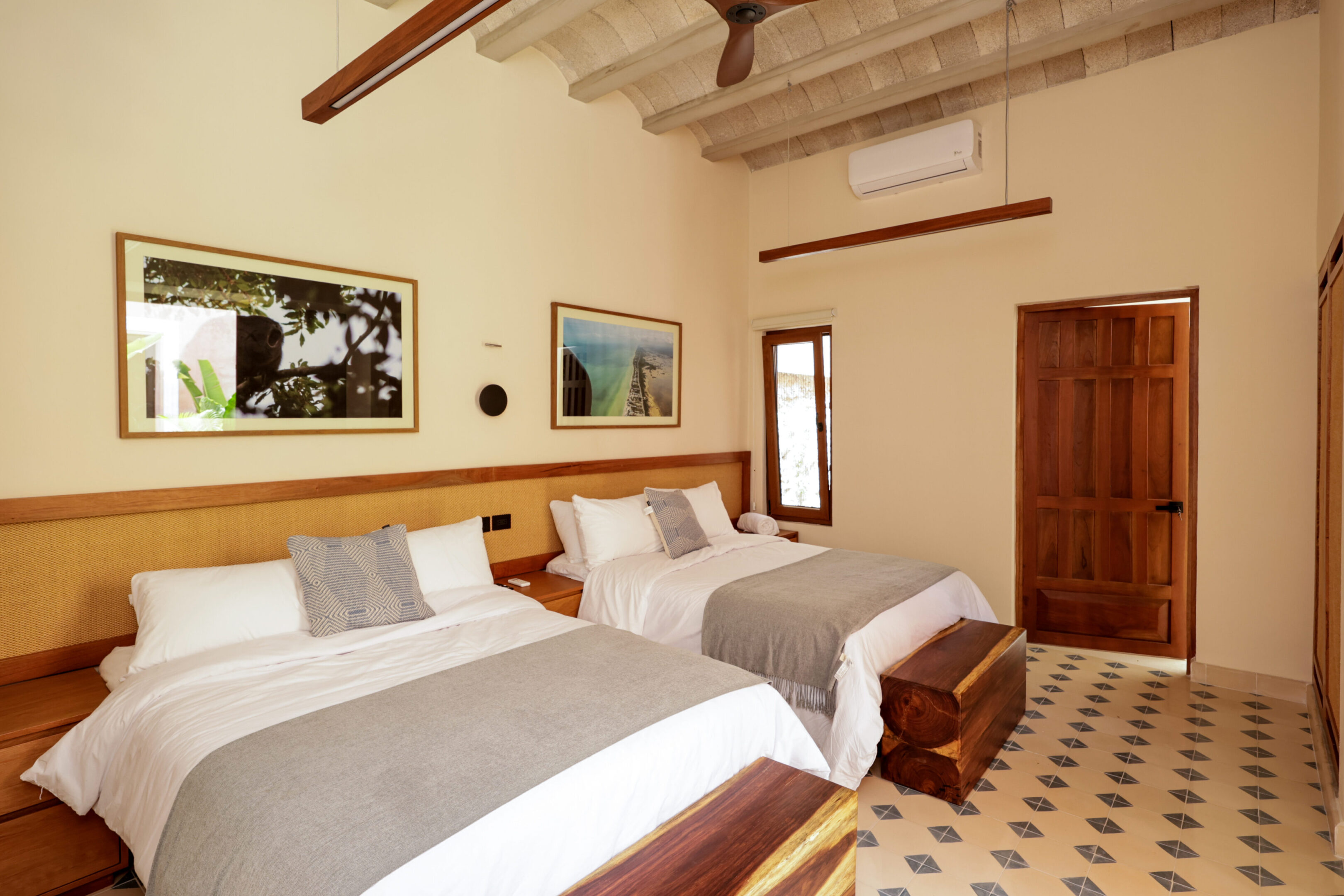 Cozy hotel room with twin beds and warm decor.