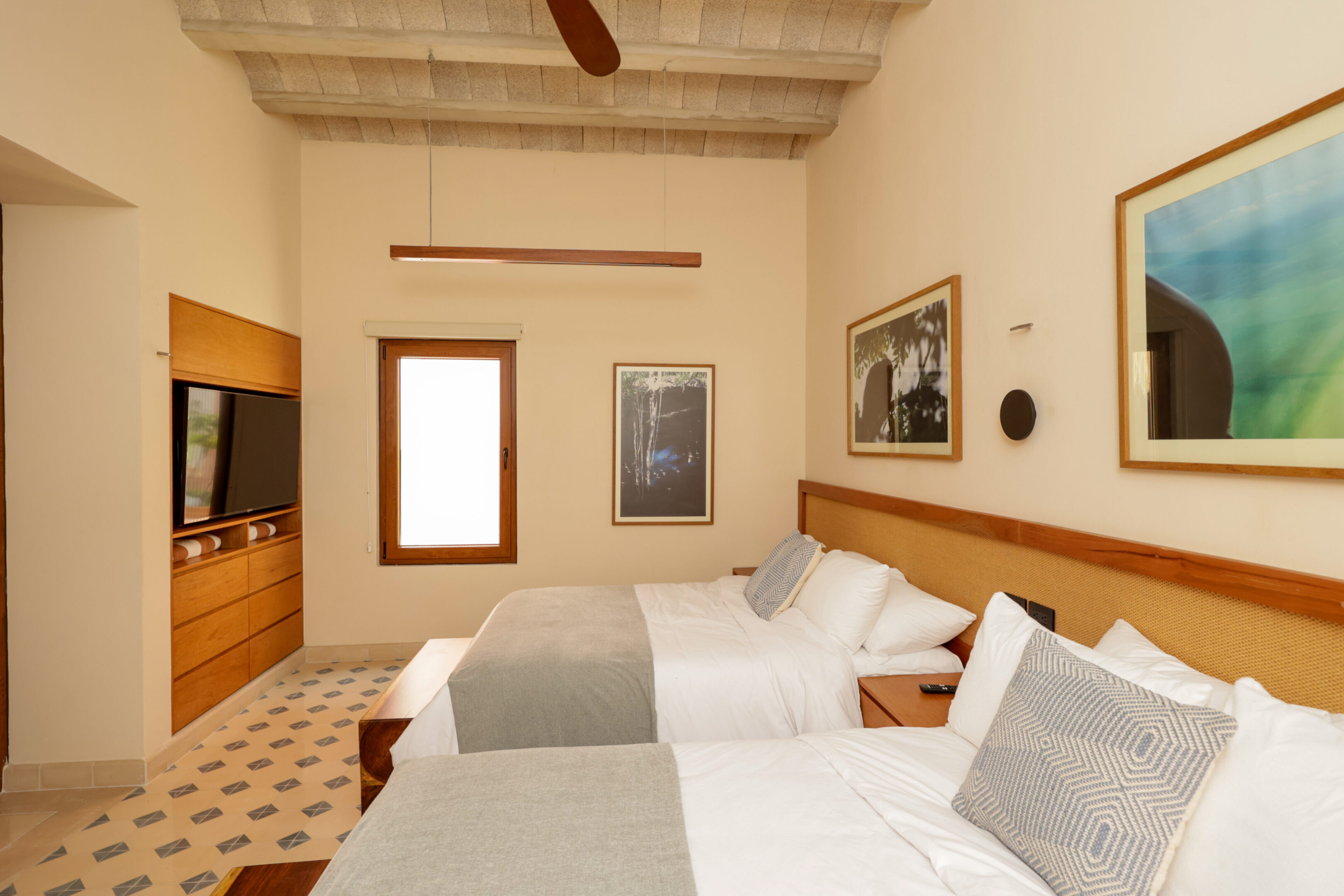 Cozy hotel room with twin beds and warm lighting.