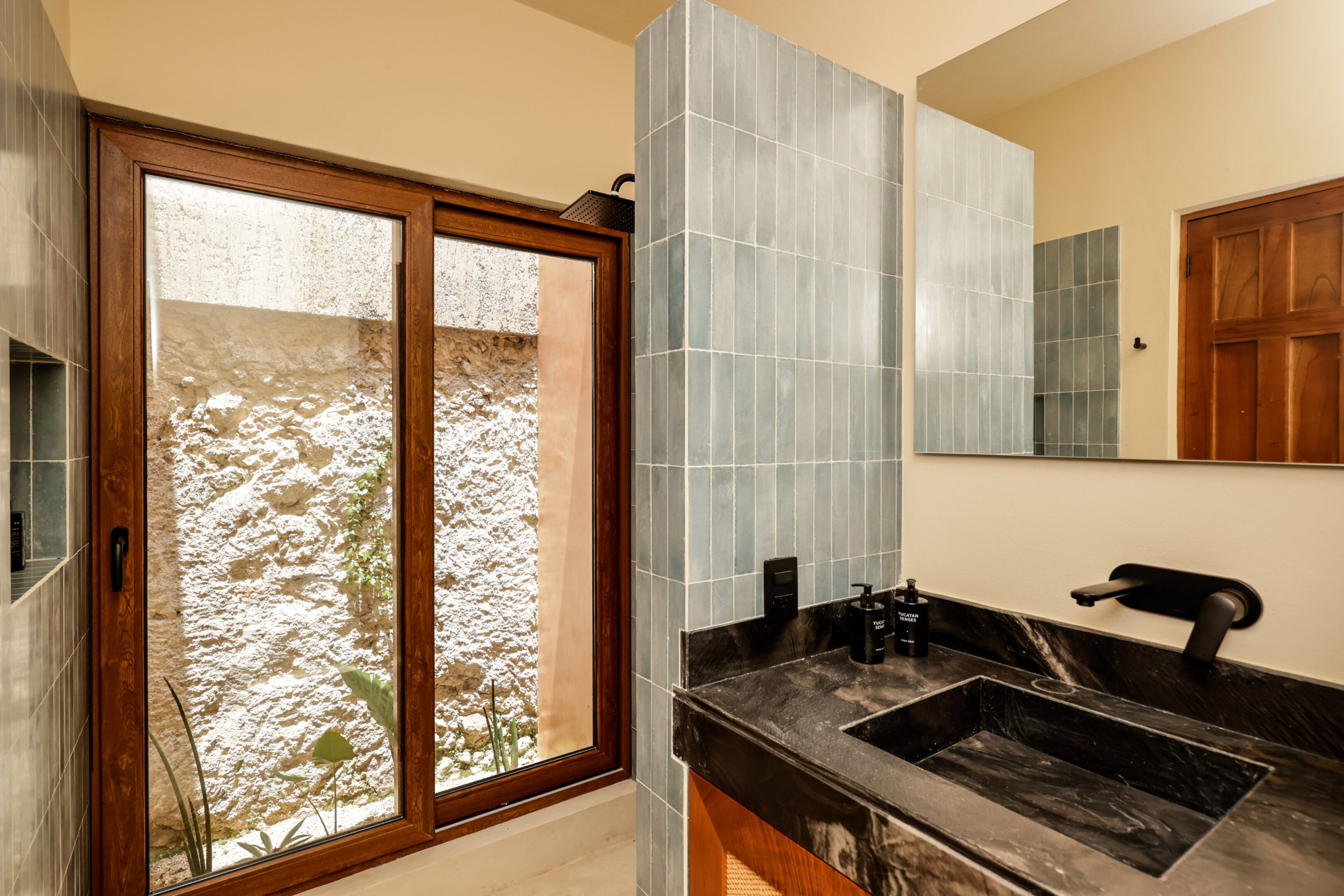Bathroom with large wood-framed glass doors and stone sink.
