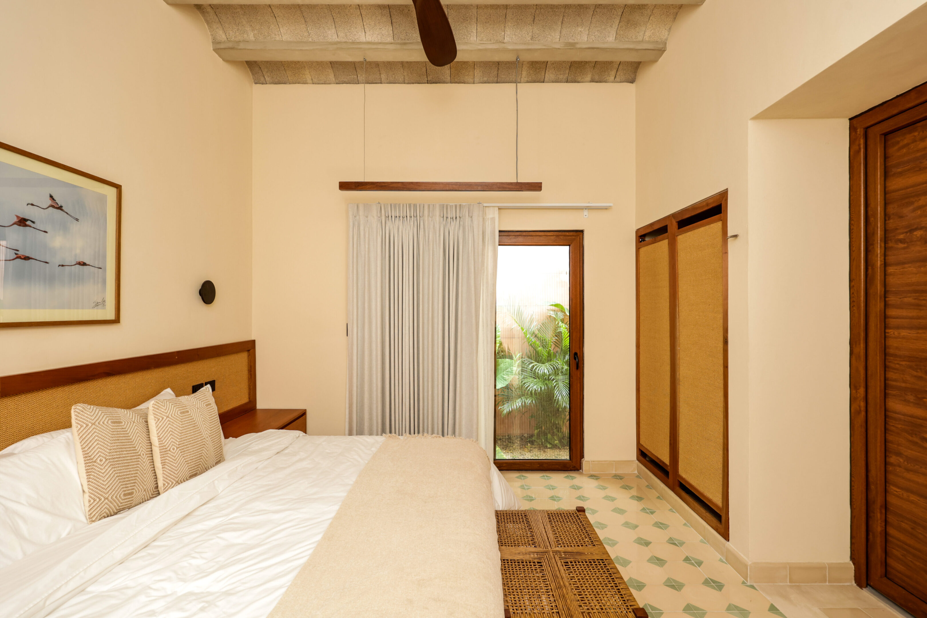 Cozy bedroom with wooden ceiling beams and warm lighting.