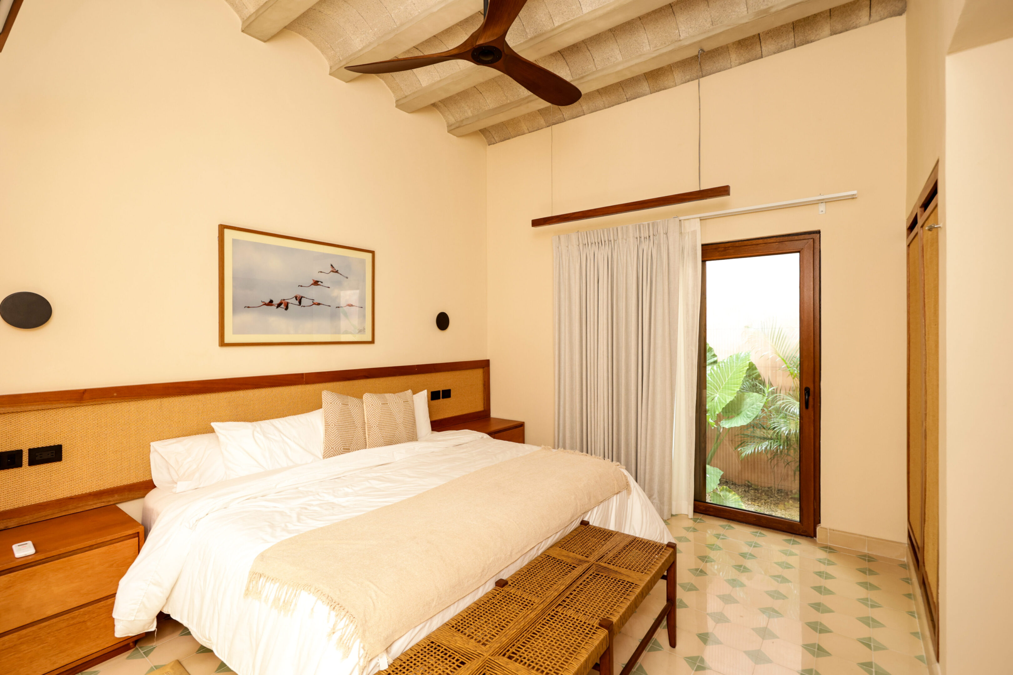 Cozy, bright bedroom with wooden accents and a scenic view through the glass door.