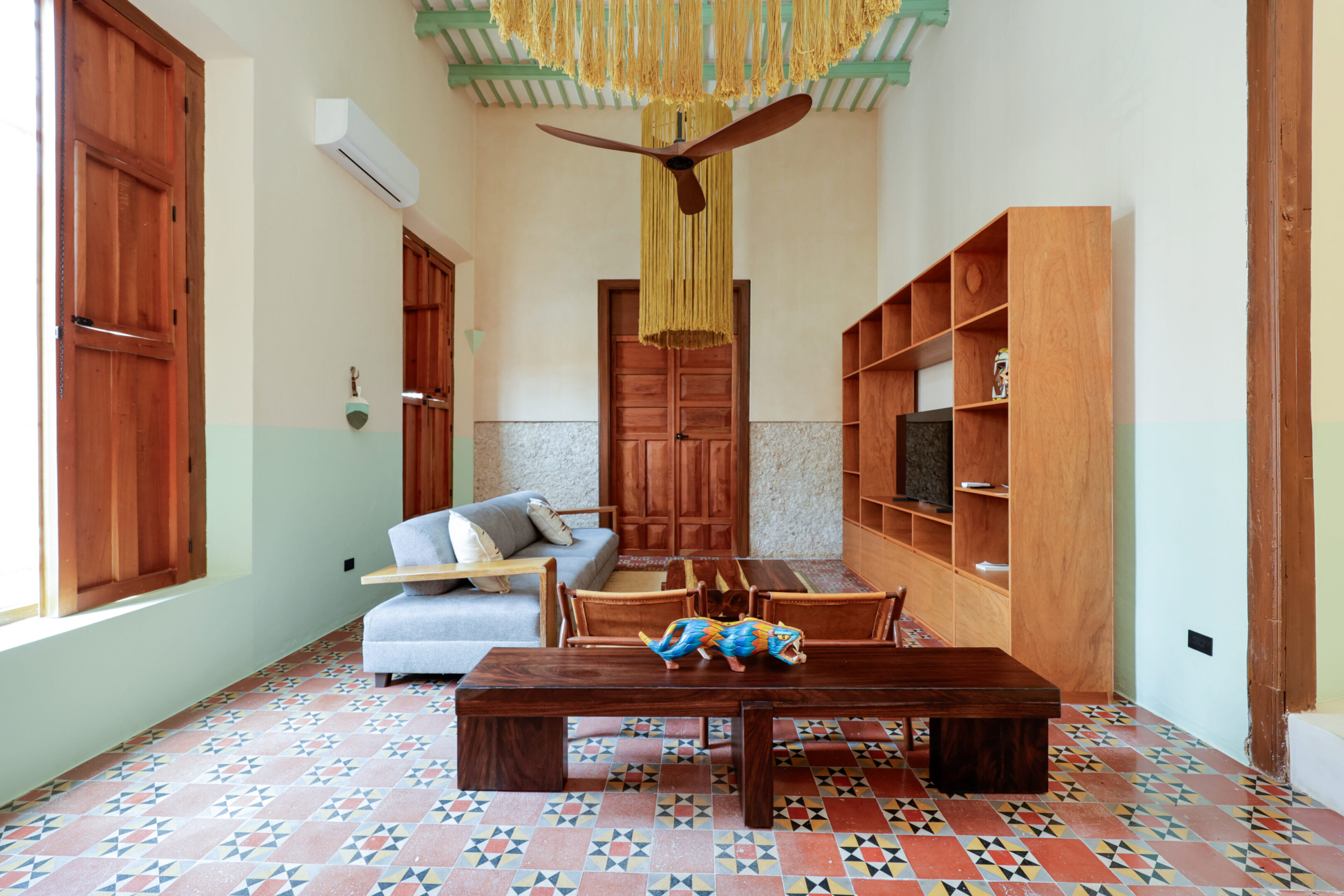 Elegant living room with wooden furniture and pastel walls.