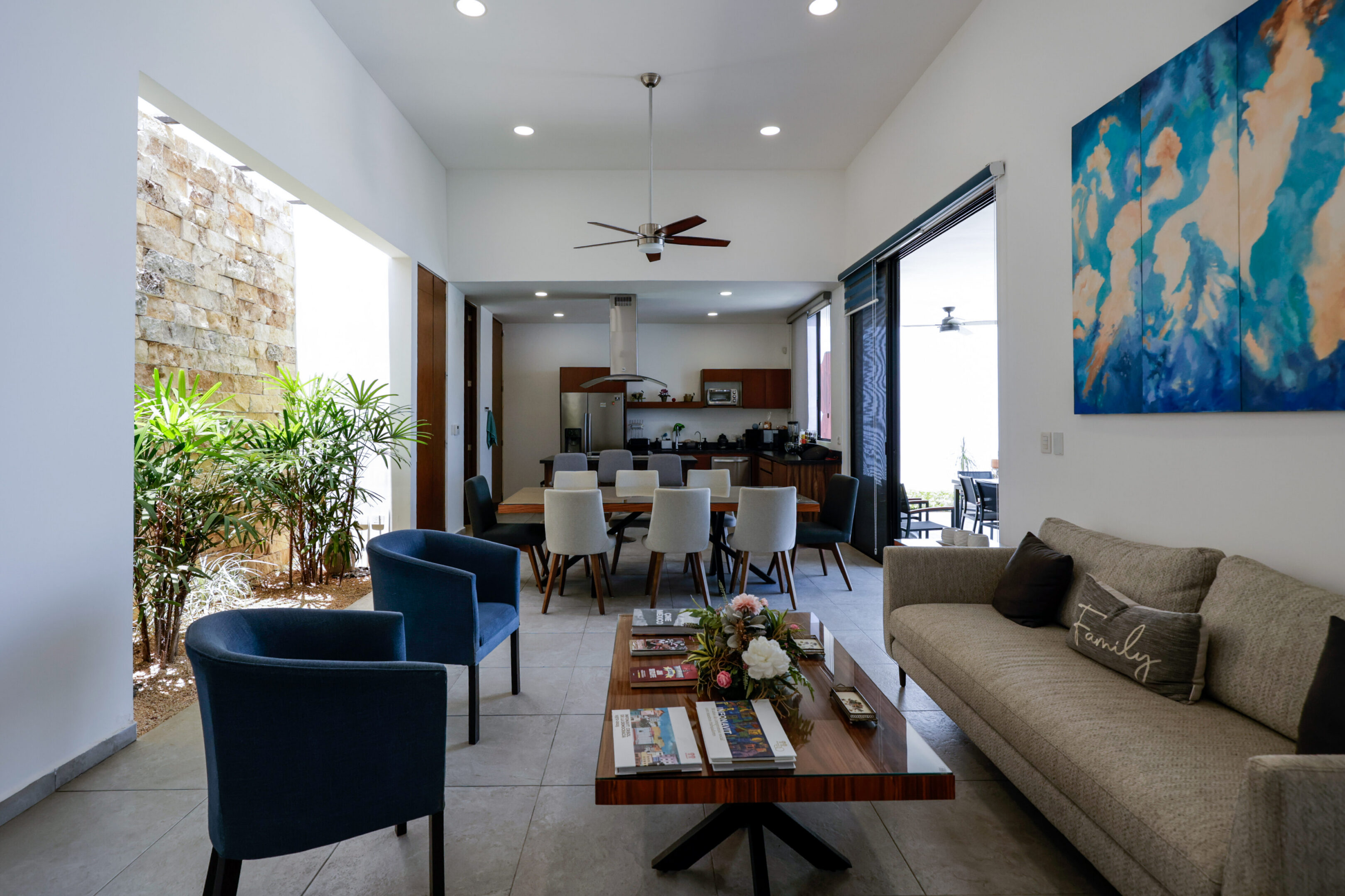 Modern living room with cozy seating and open kitchen.