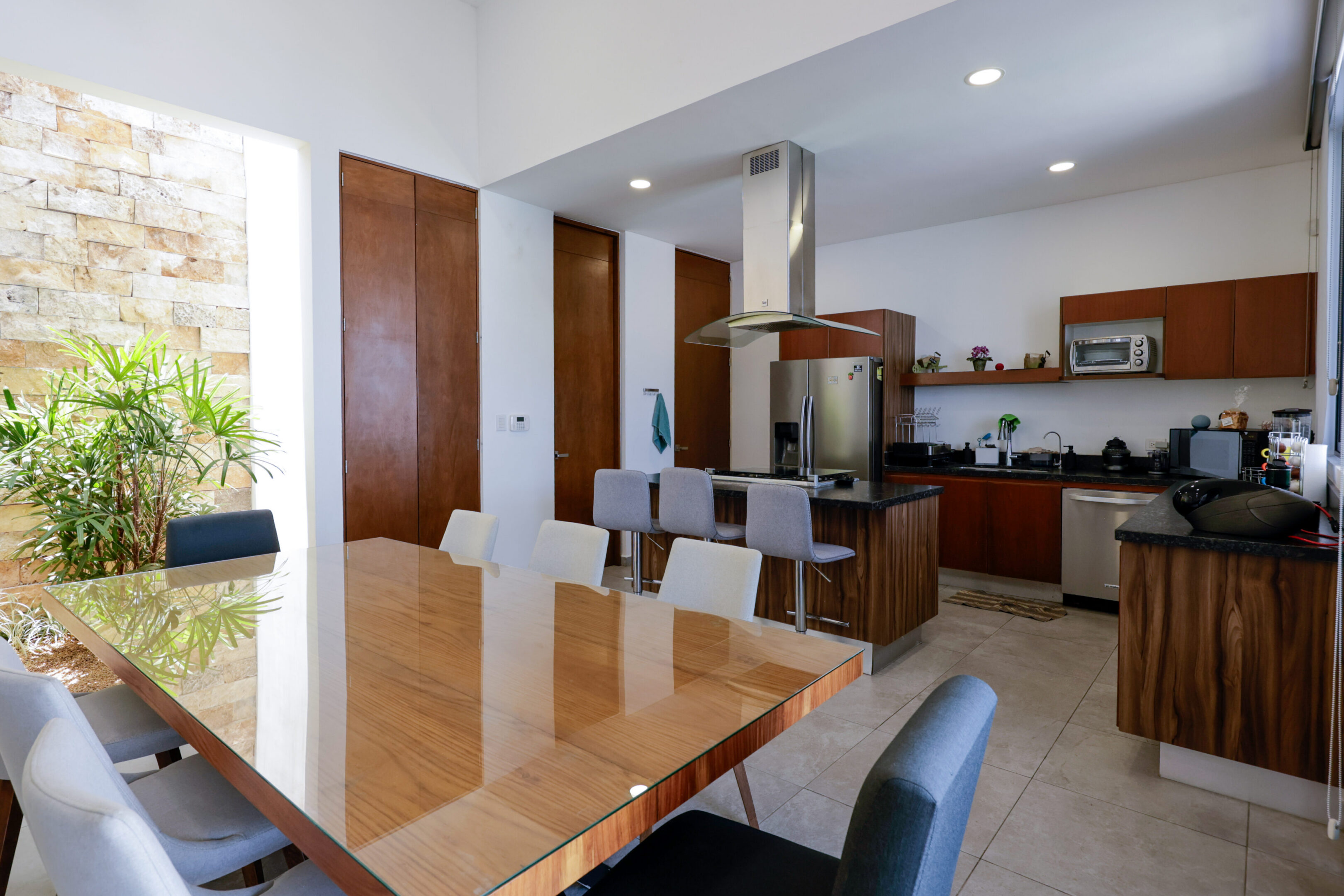 Modern kitchen and dining area with wooden accents and sleek furniture.