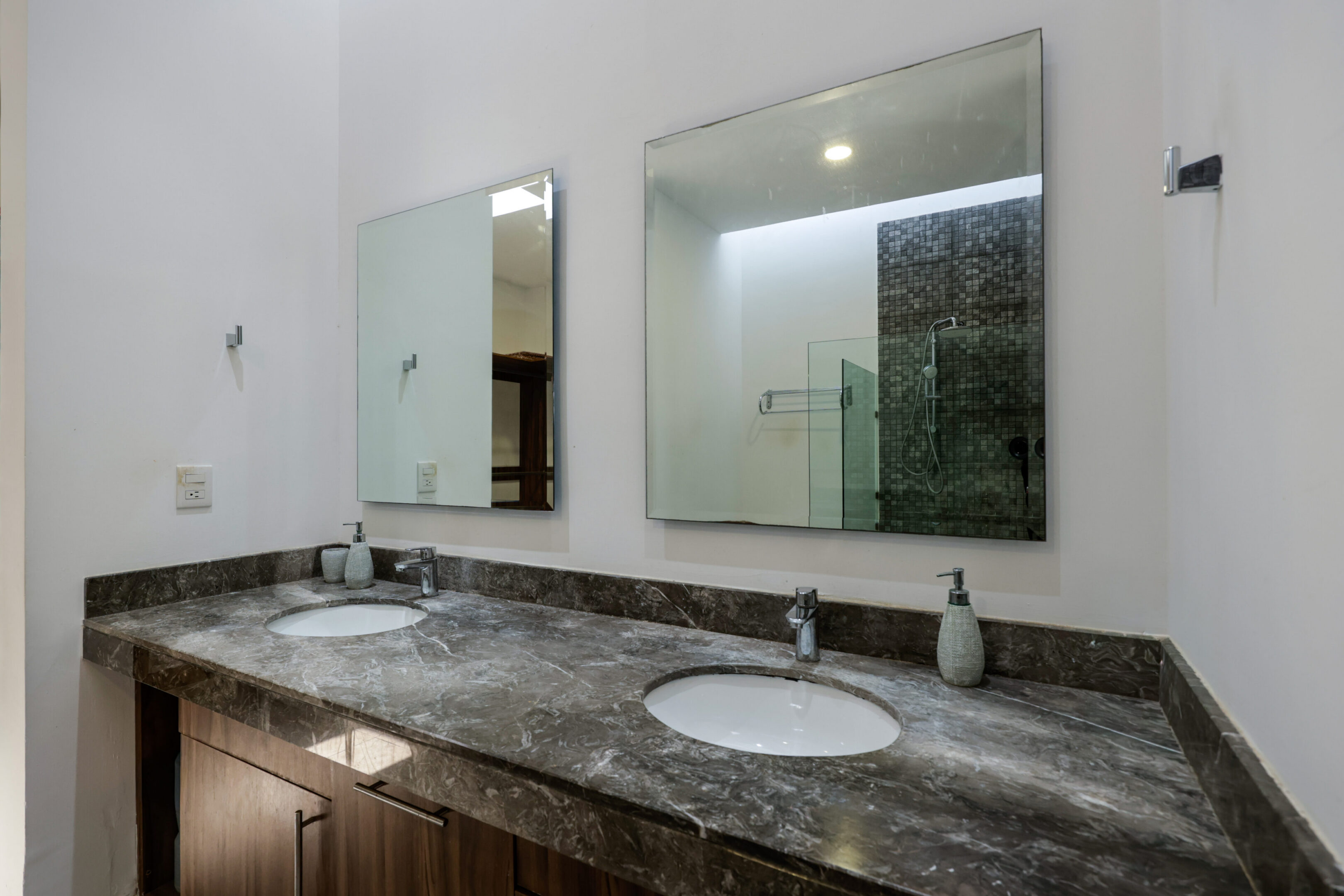 Modern bathroom with dual sinks and large mirrors.