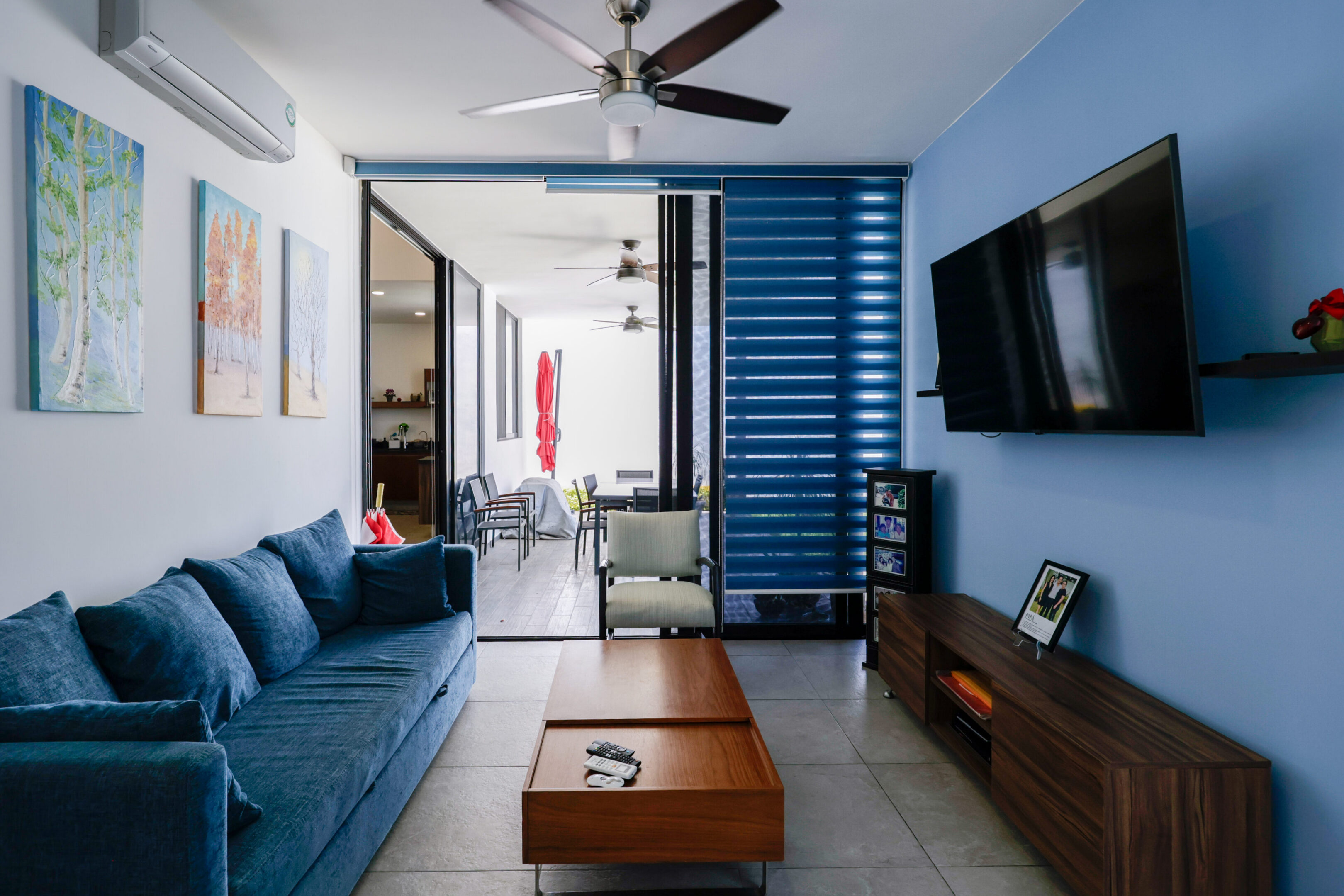 Modern living room with blue sofa and wooden coffee table.
