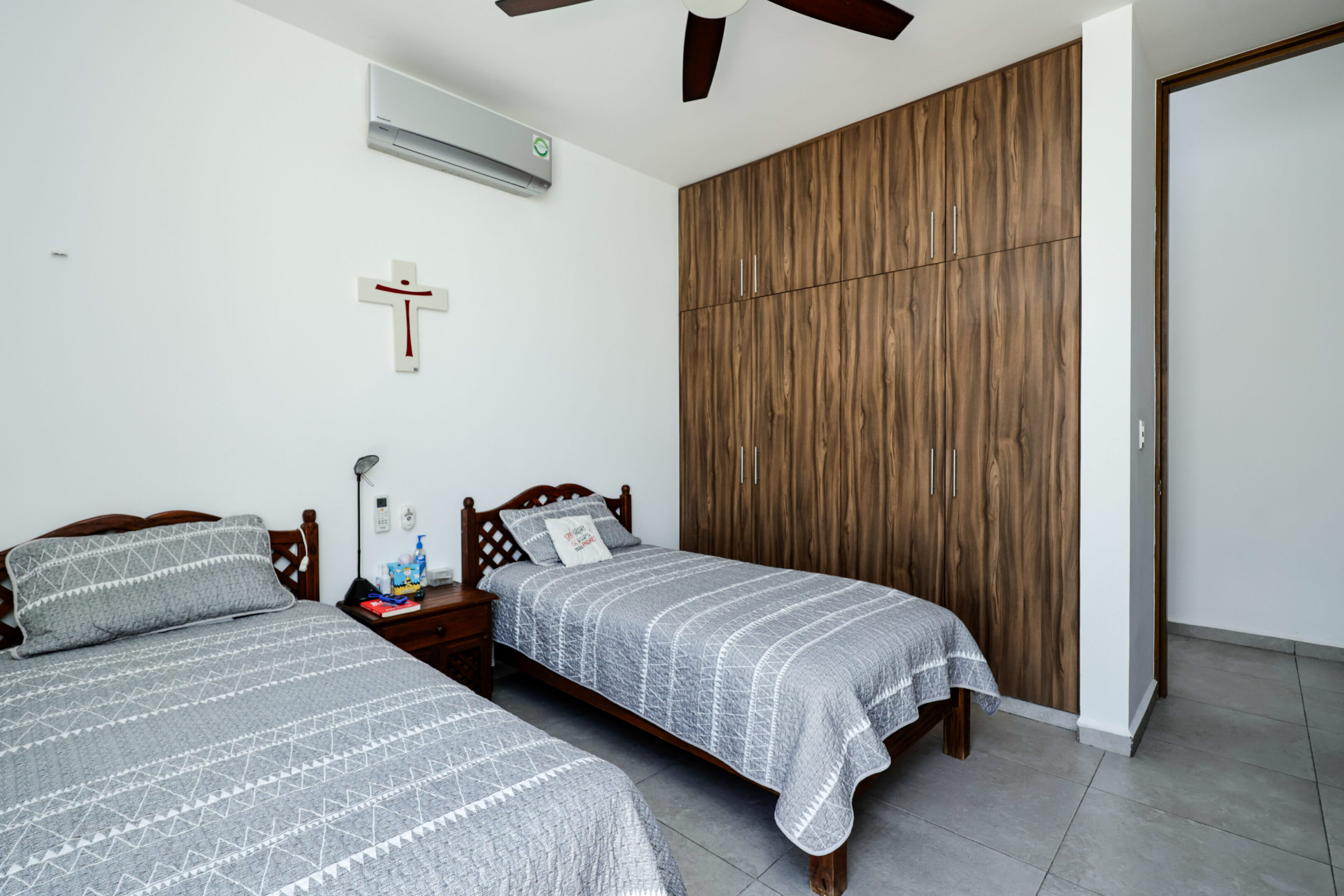 Neatly arranged bedroom with twin beds and wooden wardrobe.