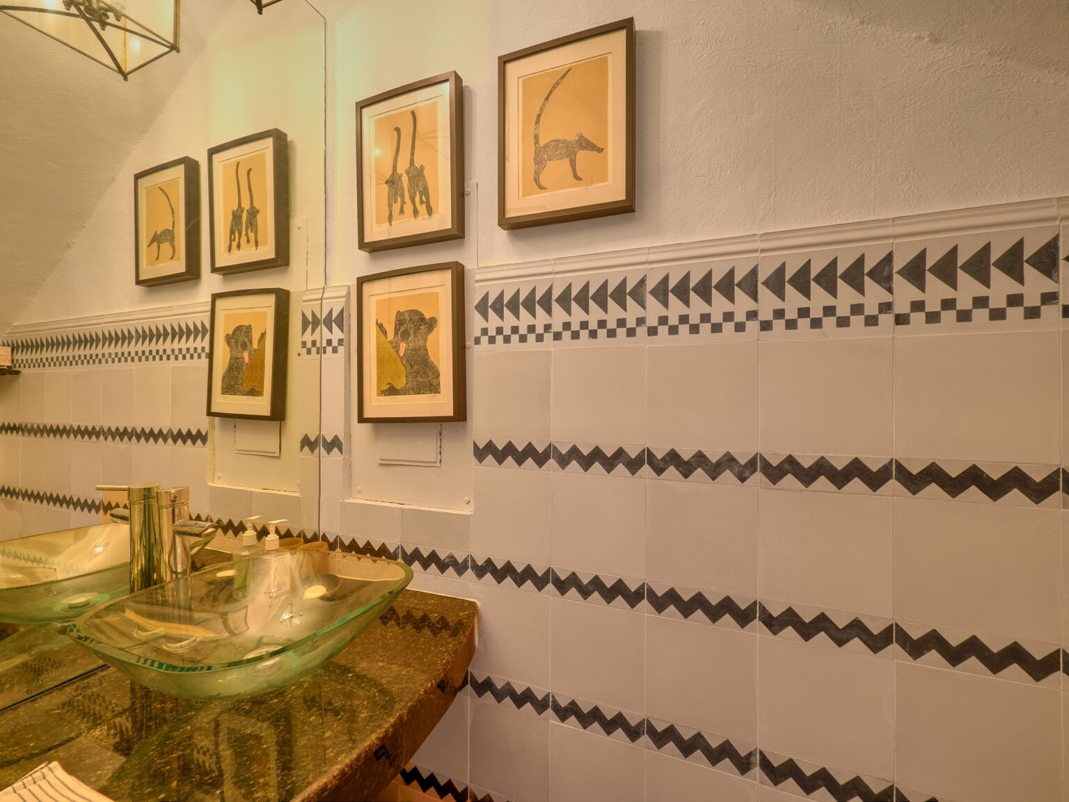 Bathroom with glass sink and animal artwork
