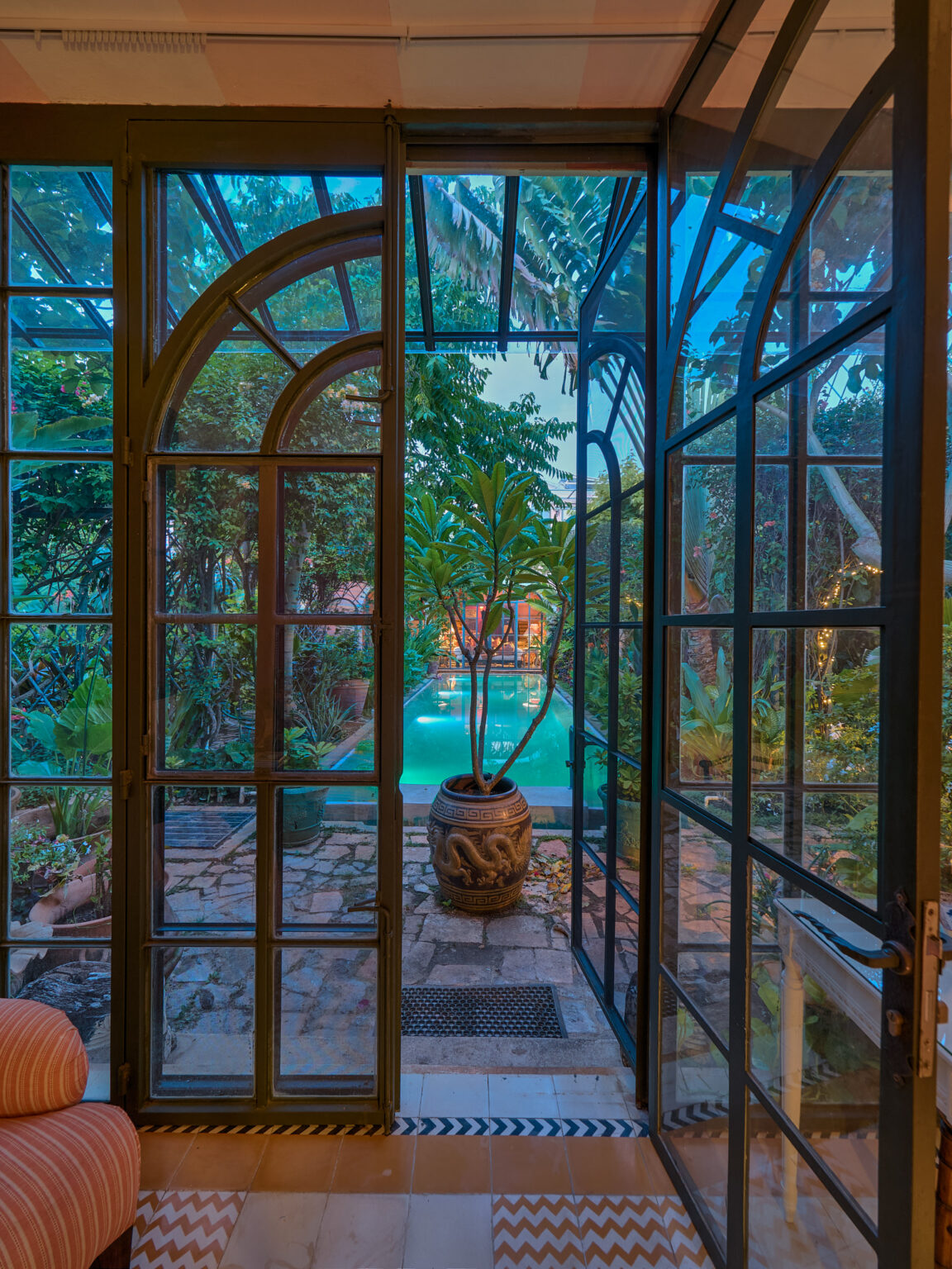 Open French doors revealing tropical pool courtyard