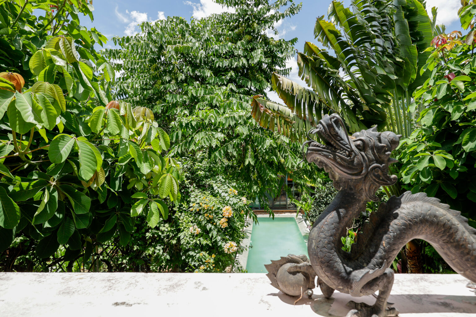 Dragon statue overlooking tropical garden pool