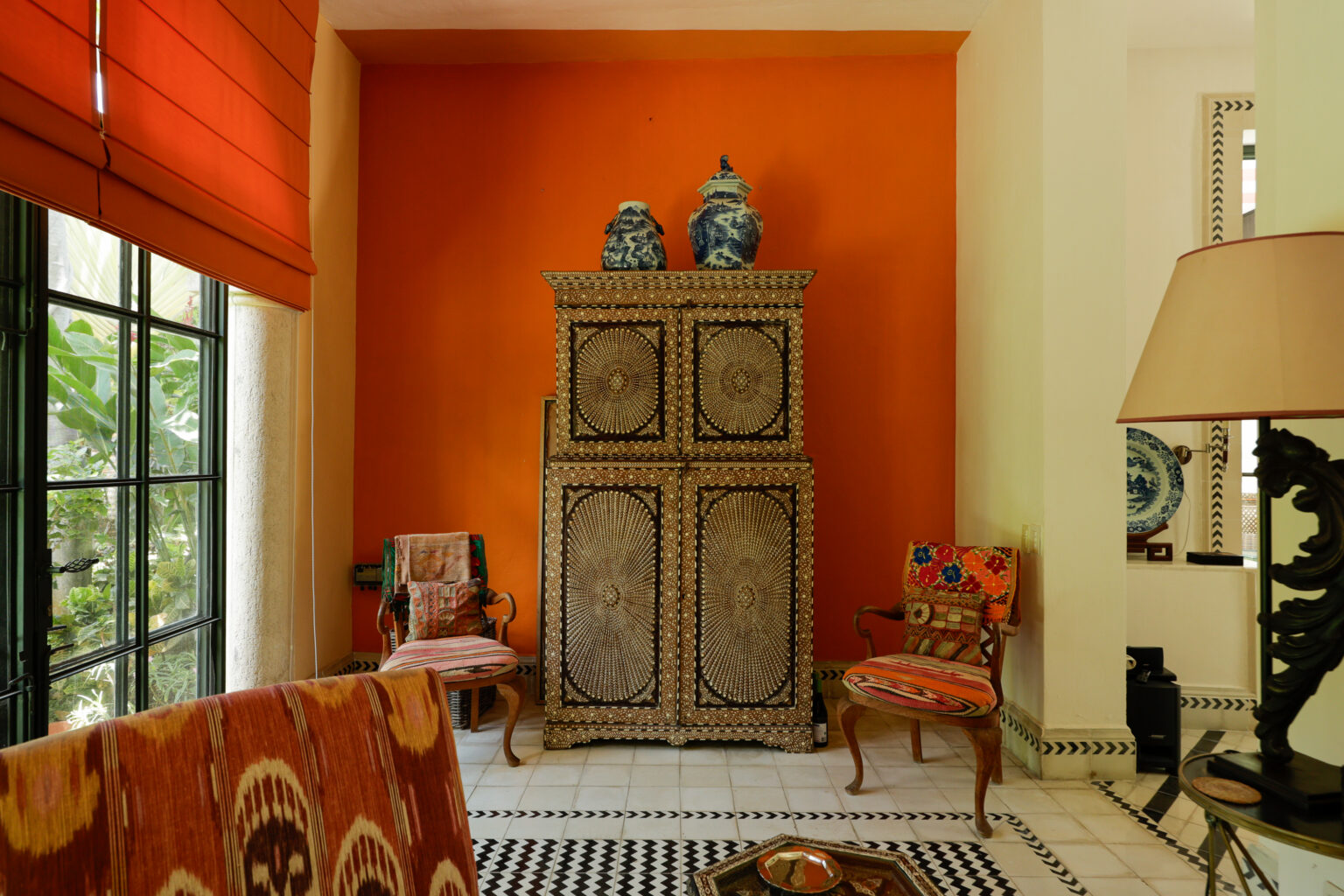 Ornate carved cabinet against vivid orange wall