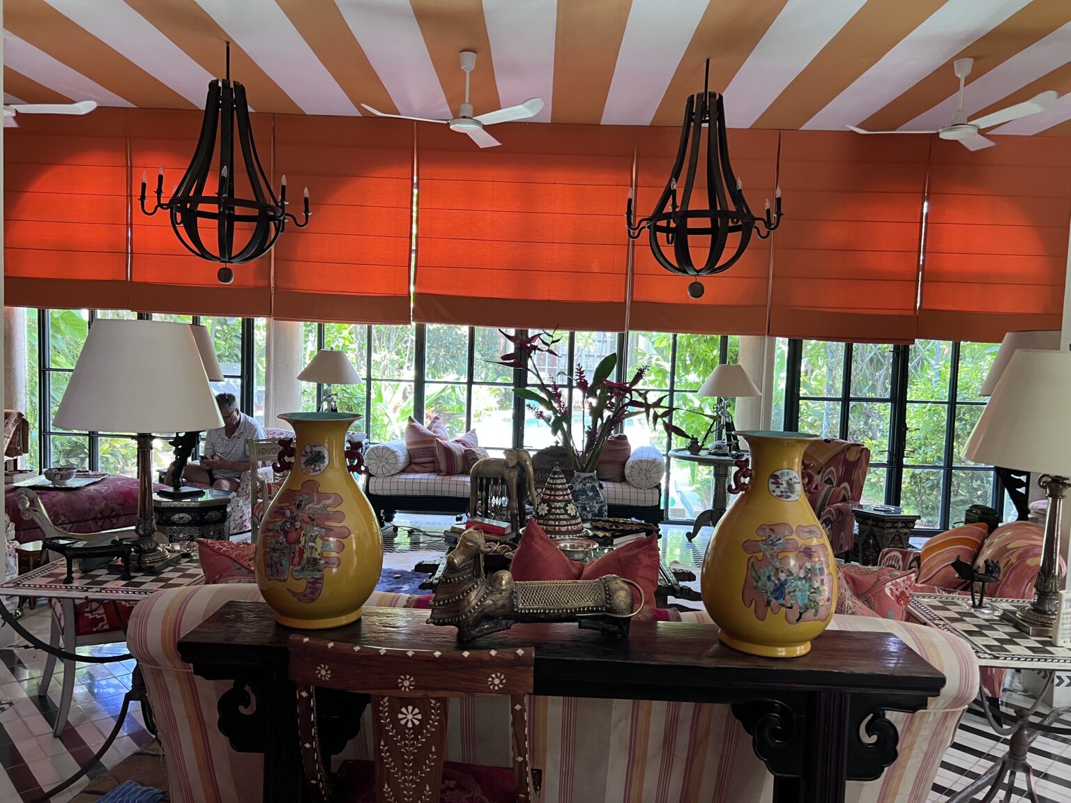 Eclectic living room with orange Roman shades