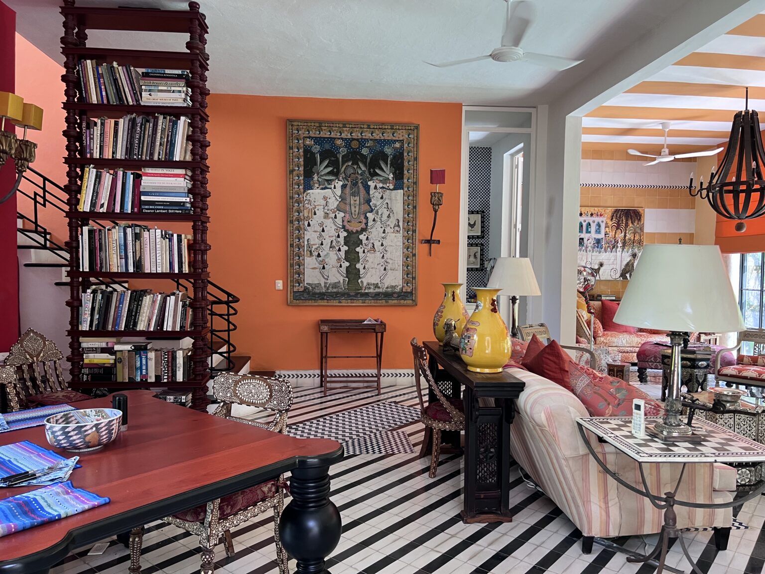 Eclectic living room with orange wall, patterned floor