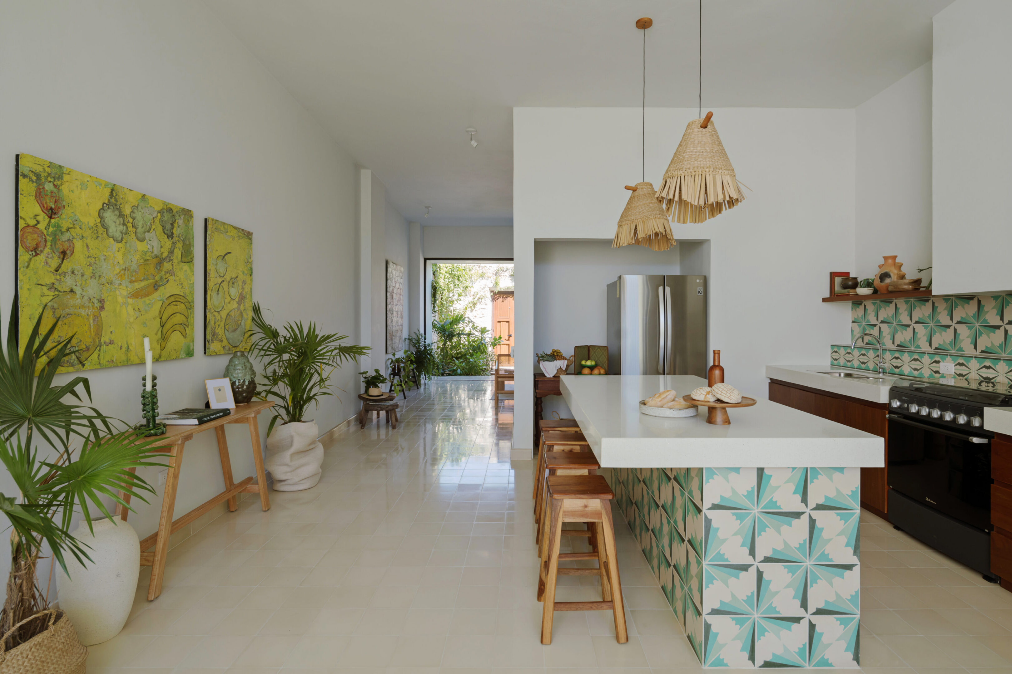 Open-plan kitchen with patterned tiled island and stools
