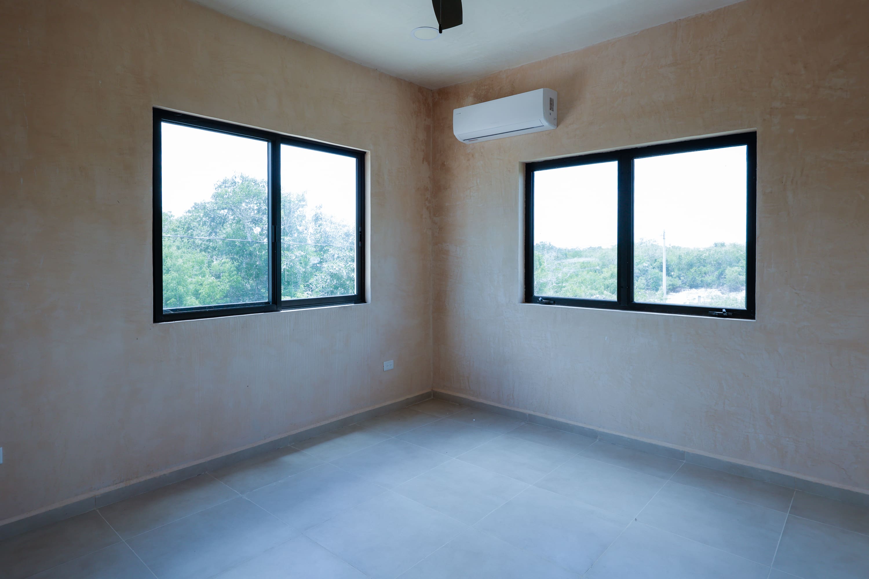 Empty room with two windows and AC