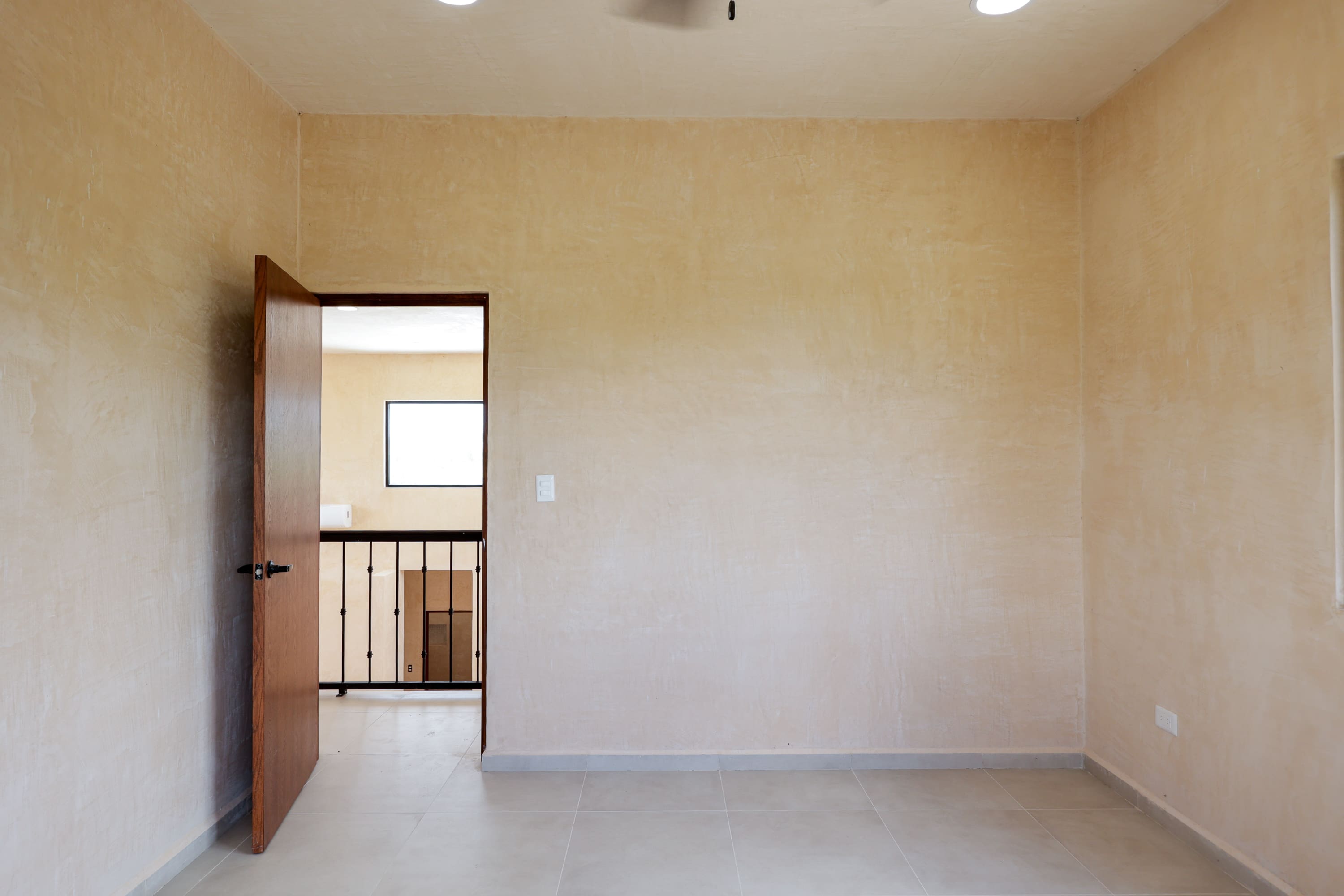 Empty beige room with open wooden door
