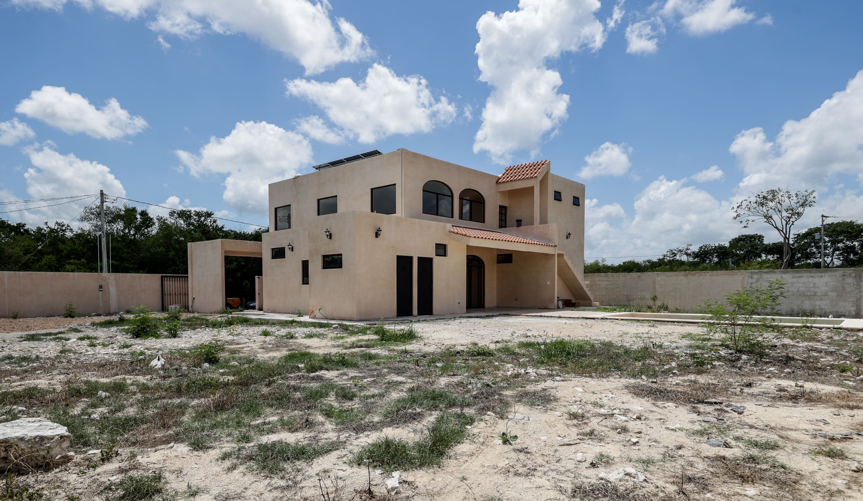 Two-story stucco house on empty lot