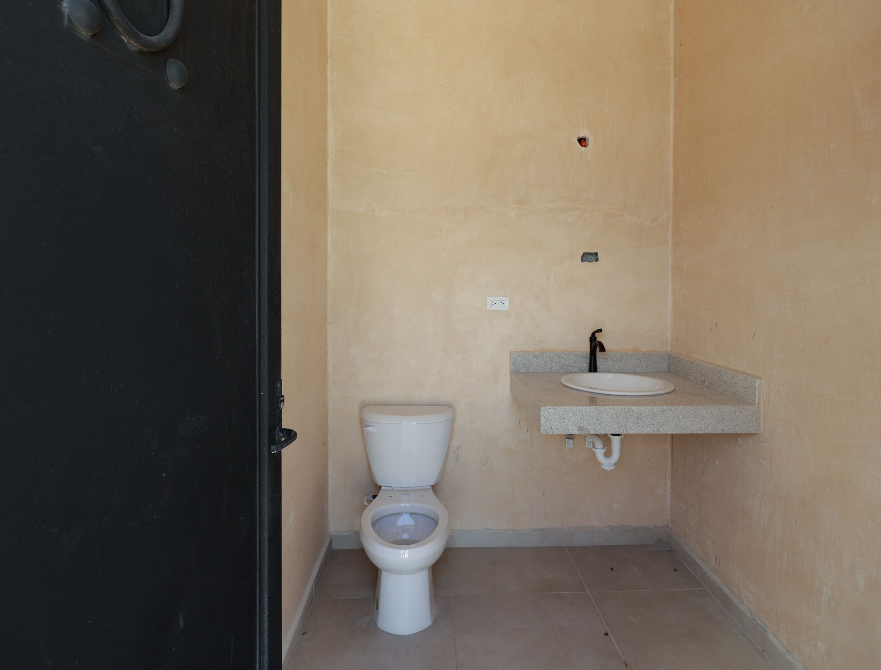 Small beige bathroom with toilet and sink