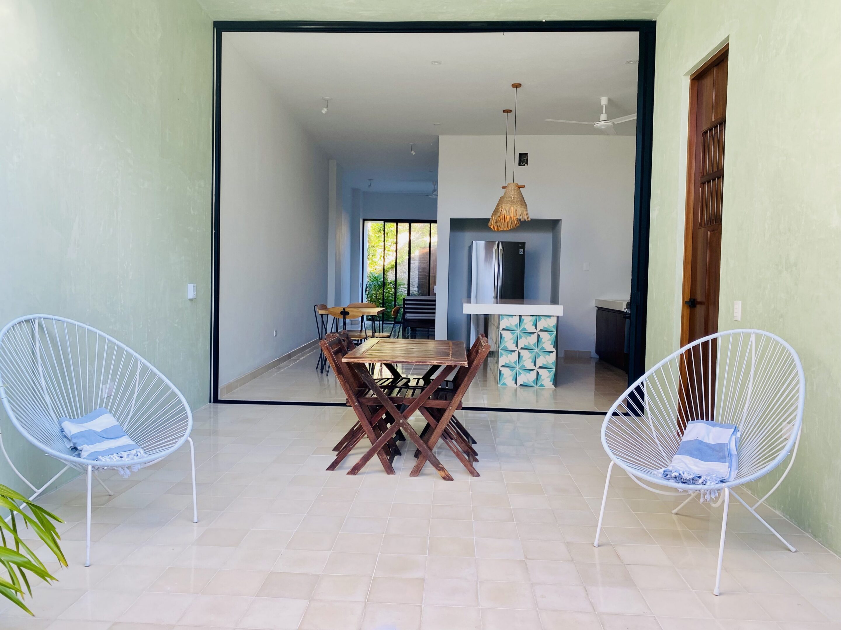 Patio with white wire chairs and wooden table