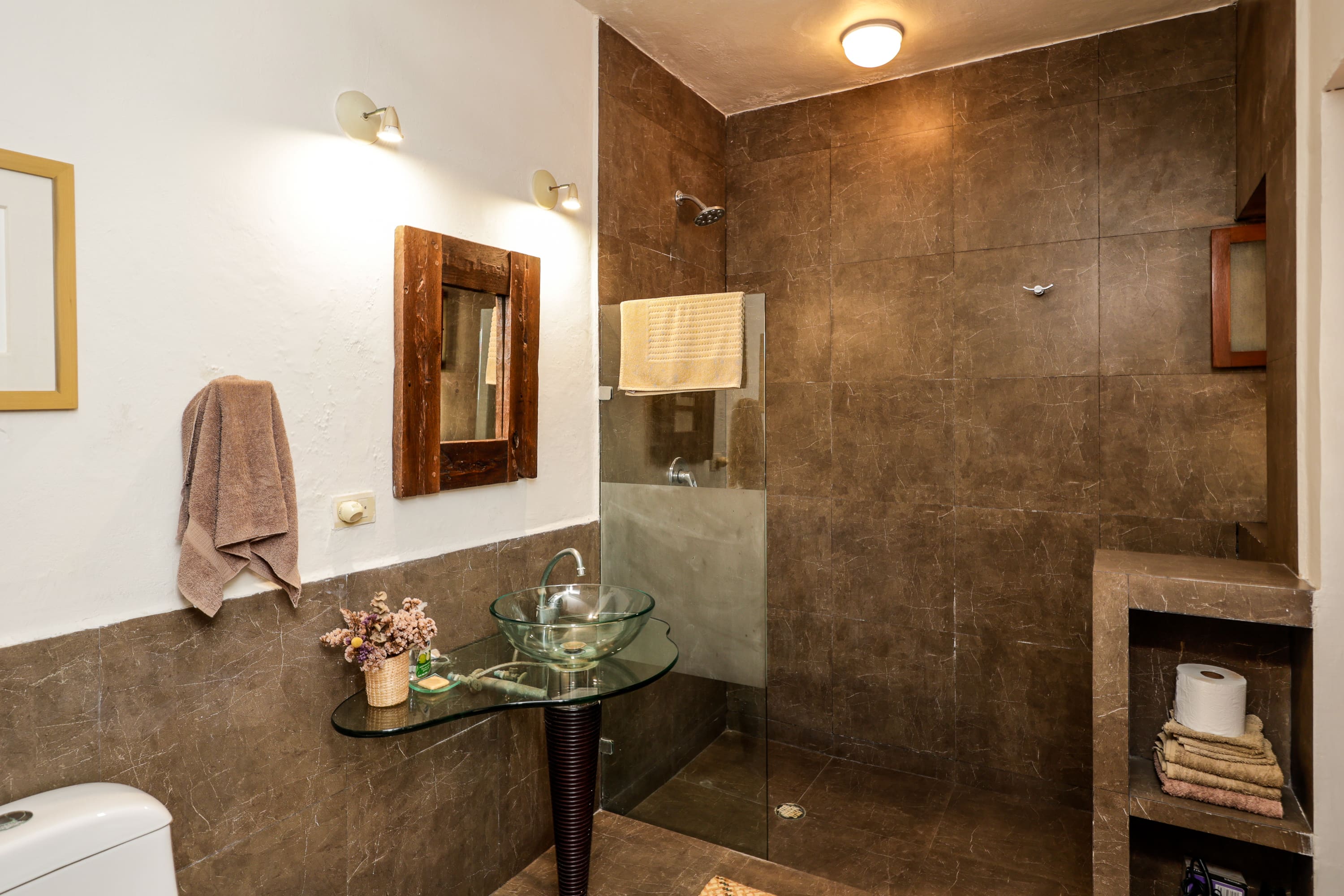 Modern bathroom with glass sink and walk-in shower