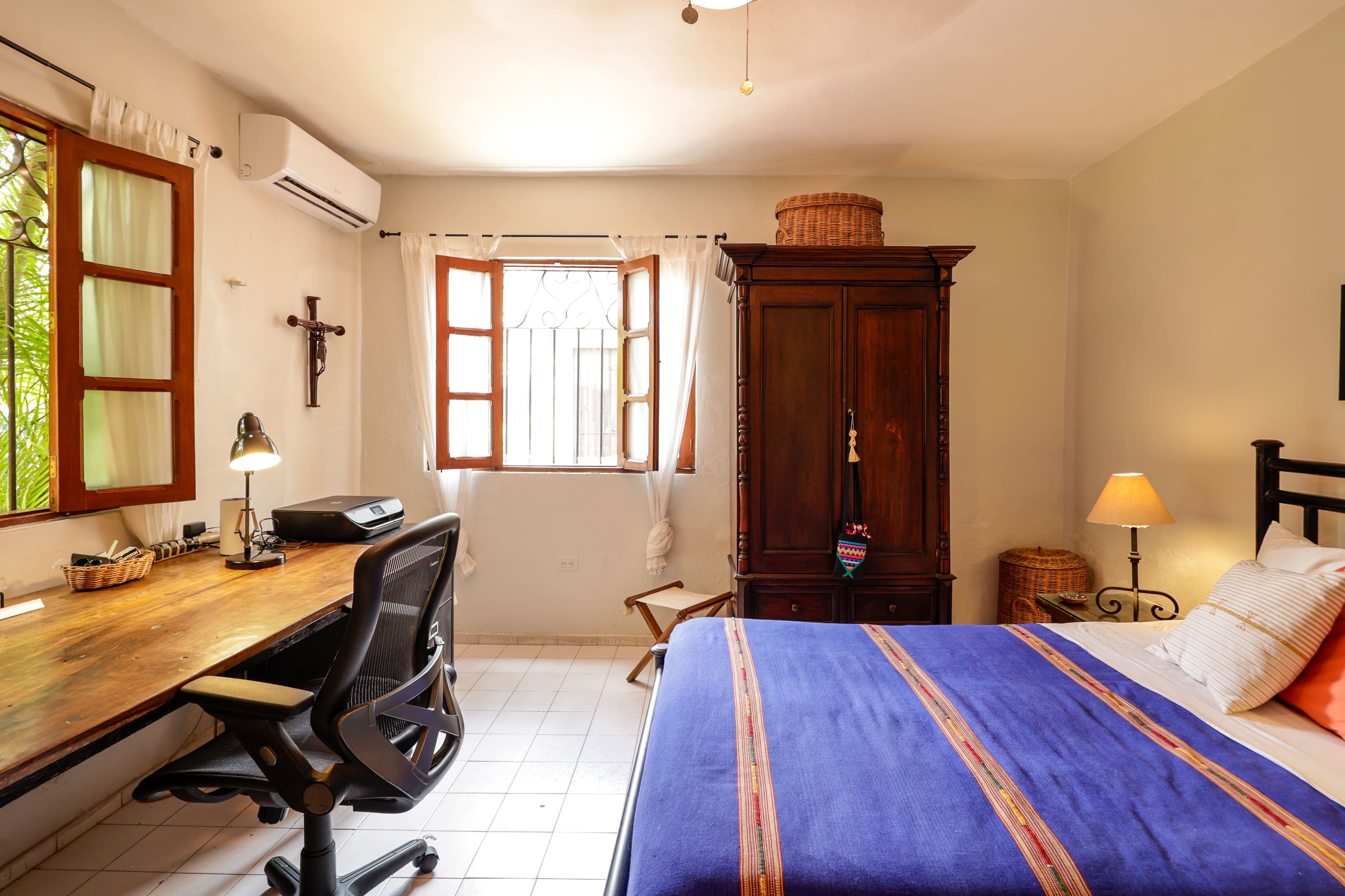 Sunlit bedroom with desk and wooden wardrobe