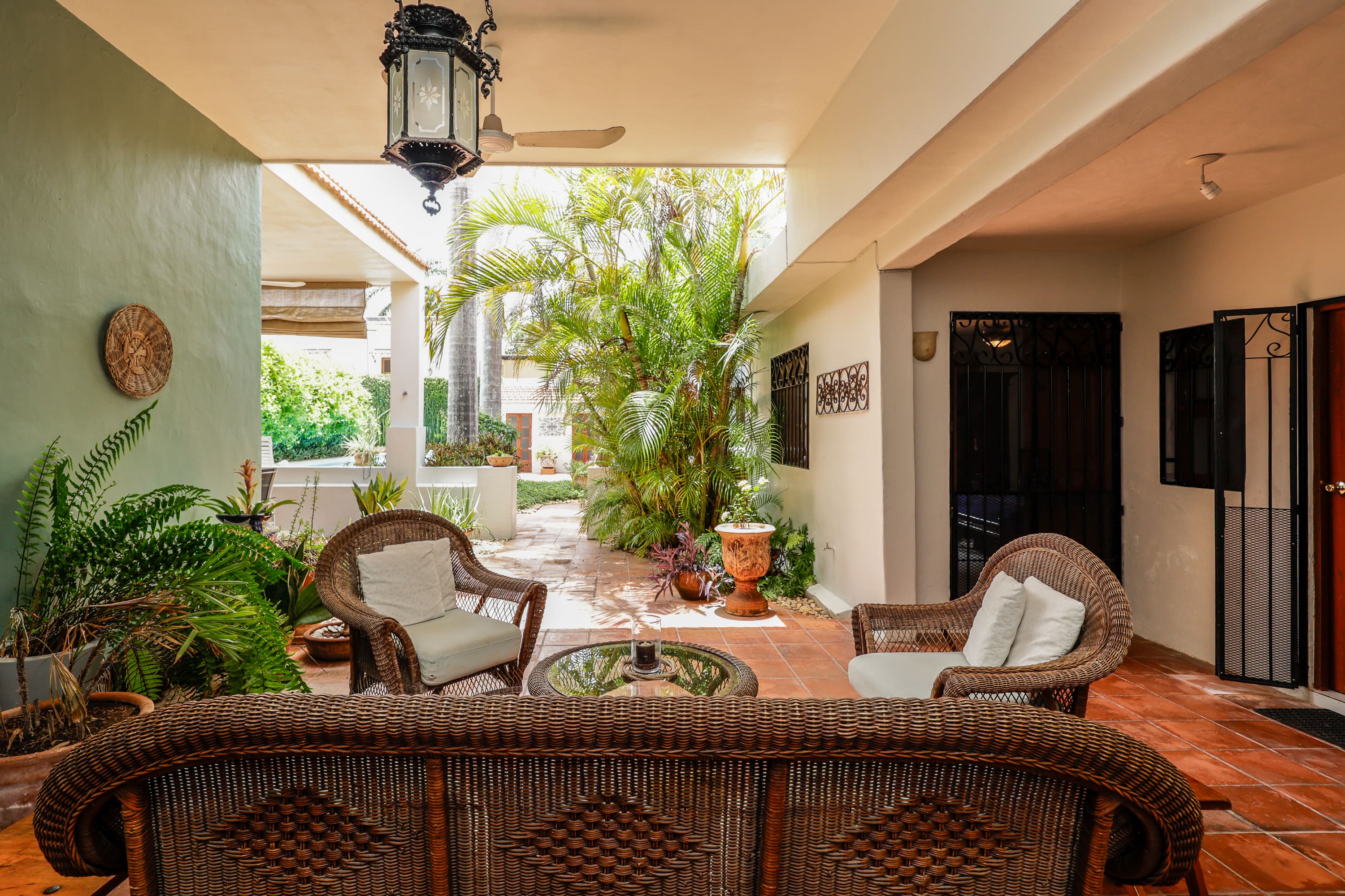 Cozy covered patio with wicker seating and plants