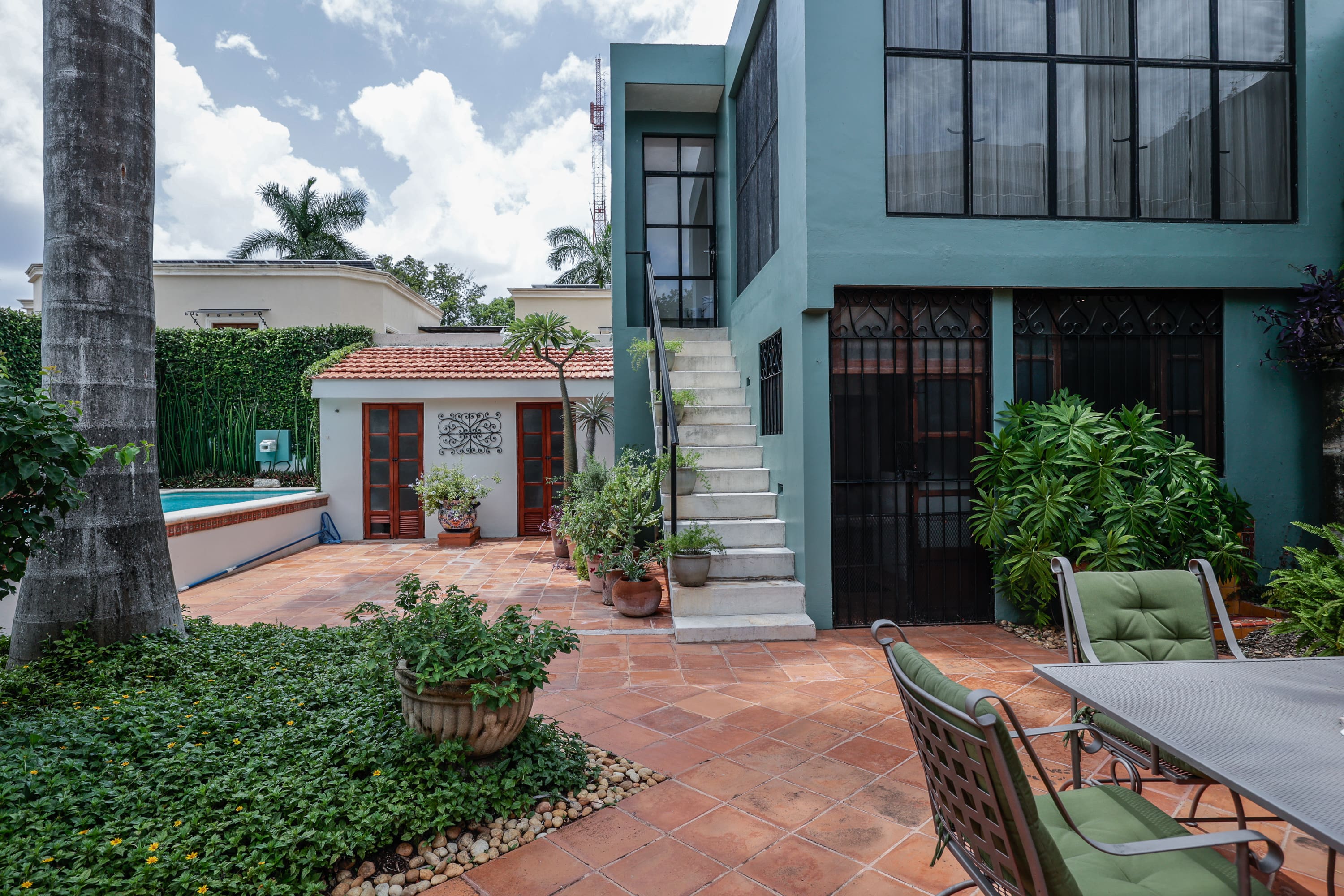 Modern teal house courtyard with pool and patio