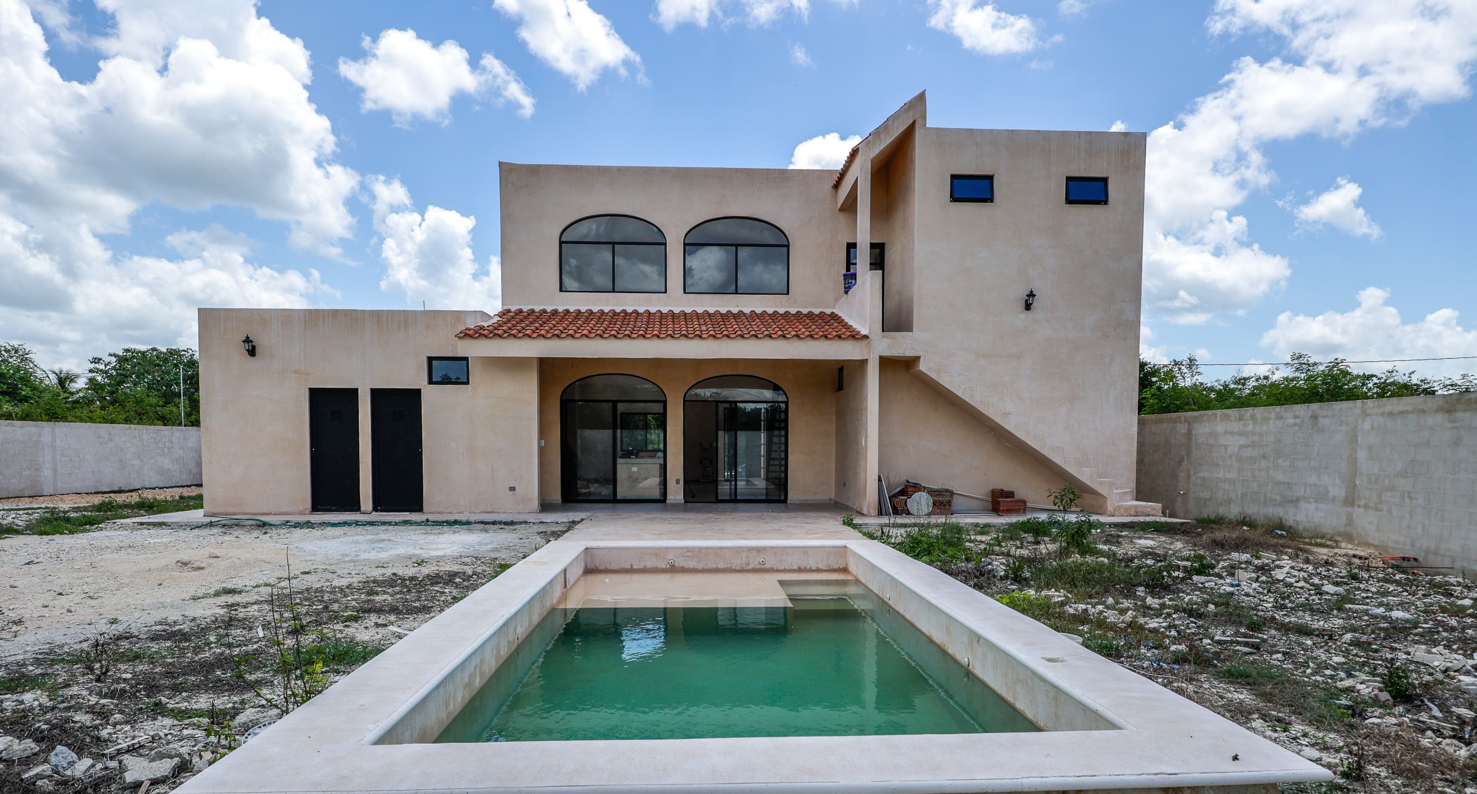 Two-story stucco house with rectangular pool