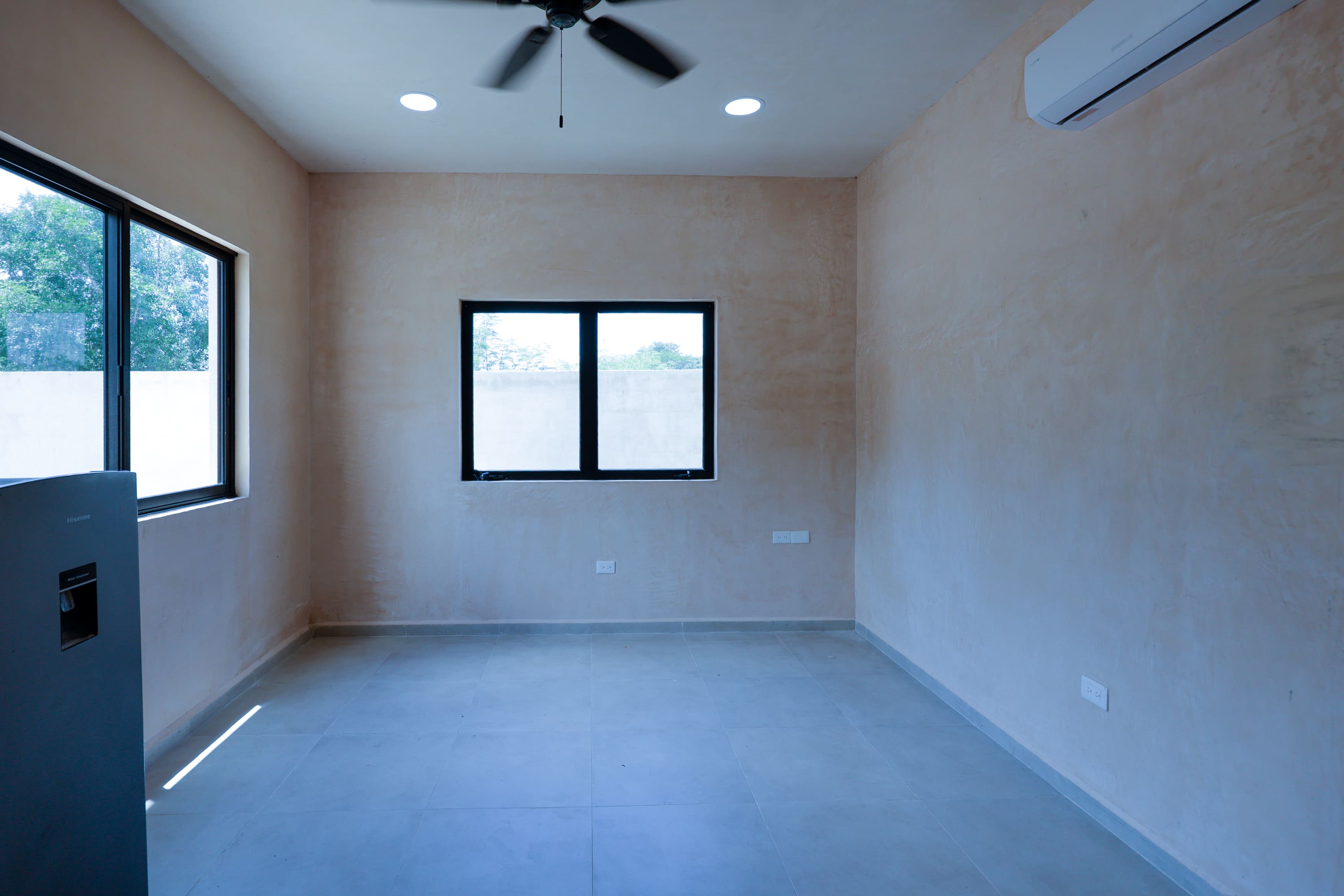 Empty room with windows, ceiling fan, AC