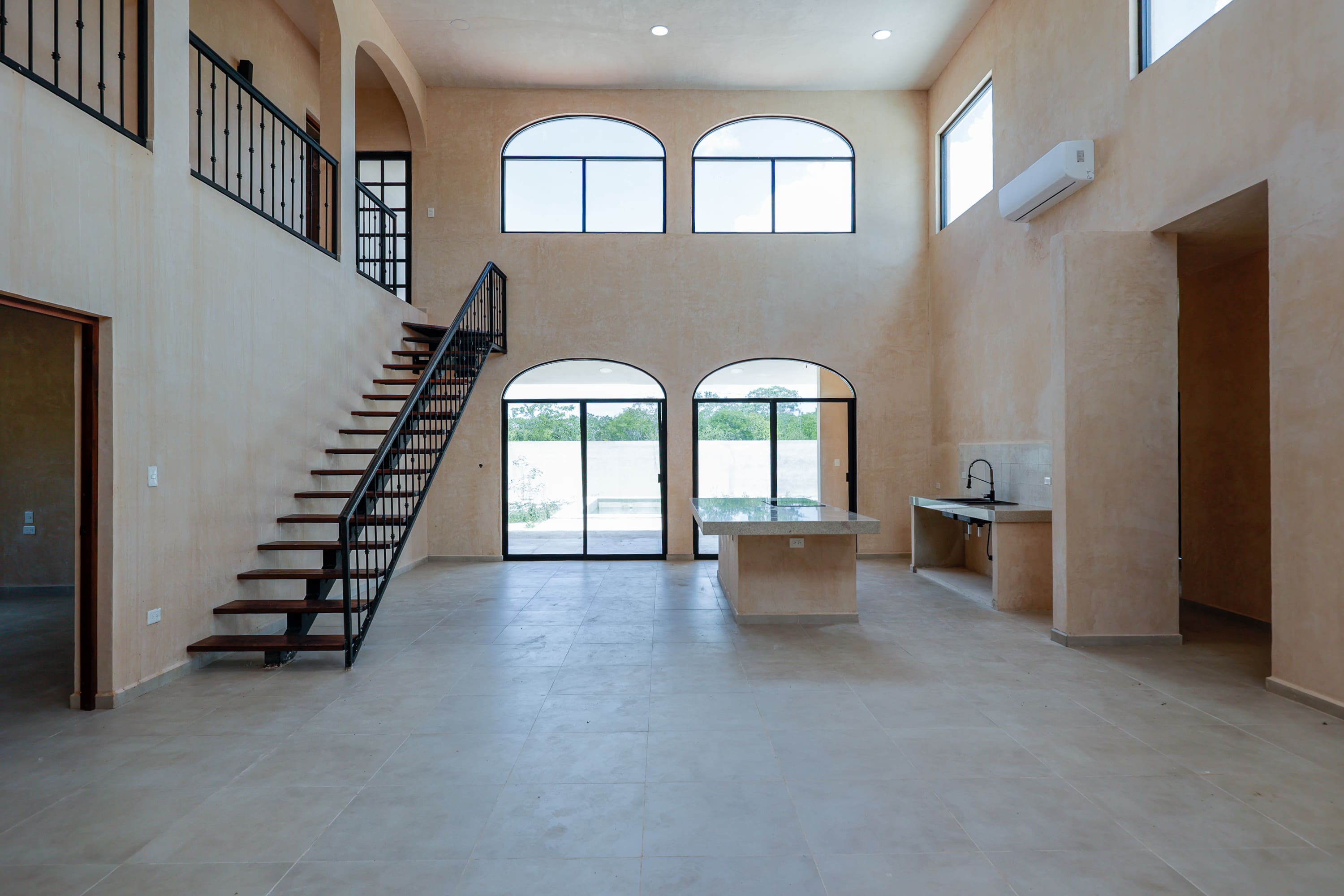 Spacious interior with arched windows and staircase