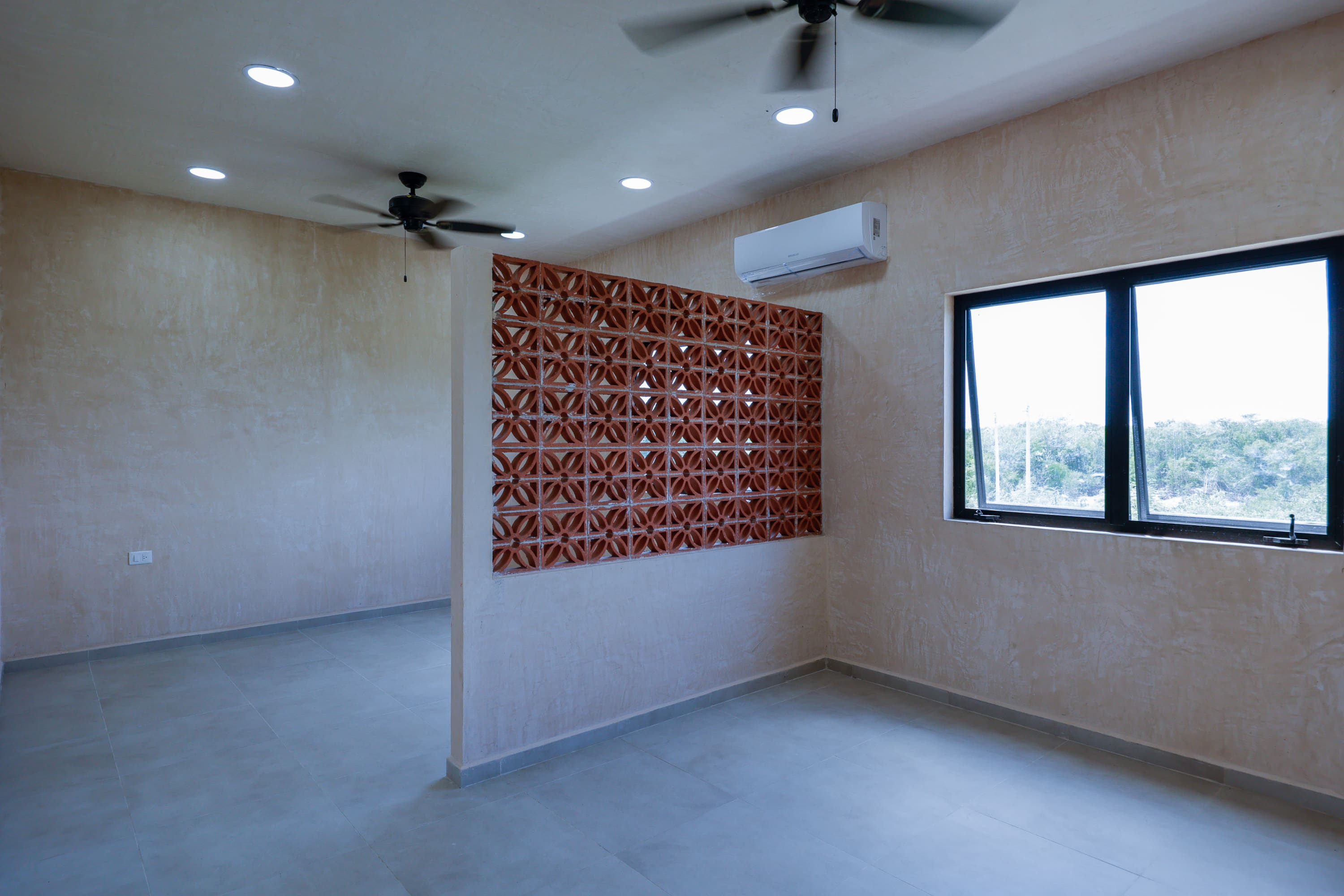 Empty modern room with ceiling fans and AC
