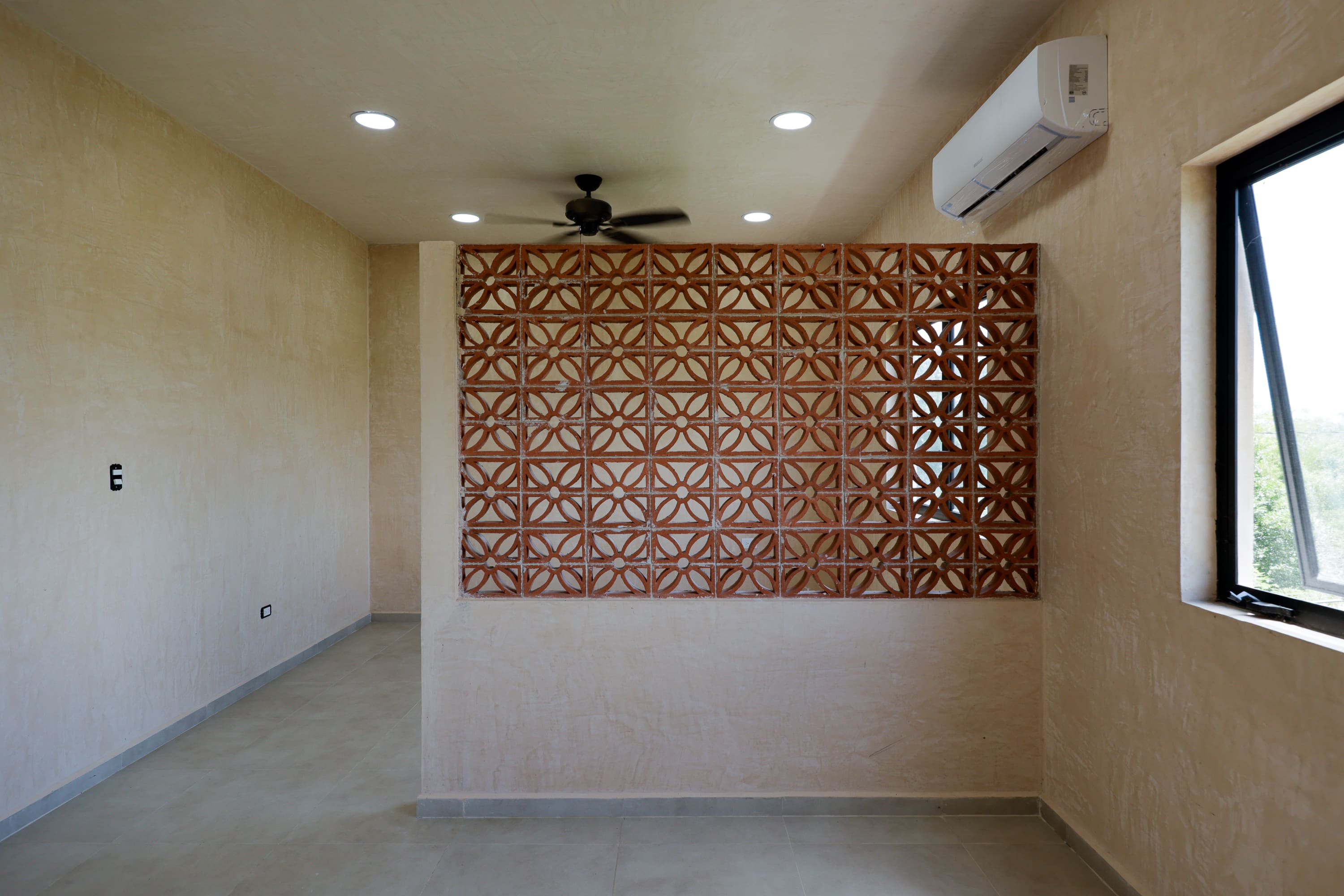 Empty plaster room with terracotta lattice partition