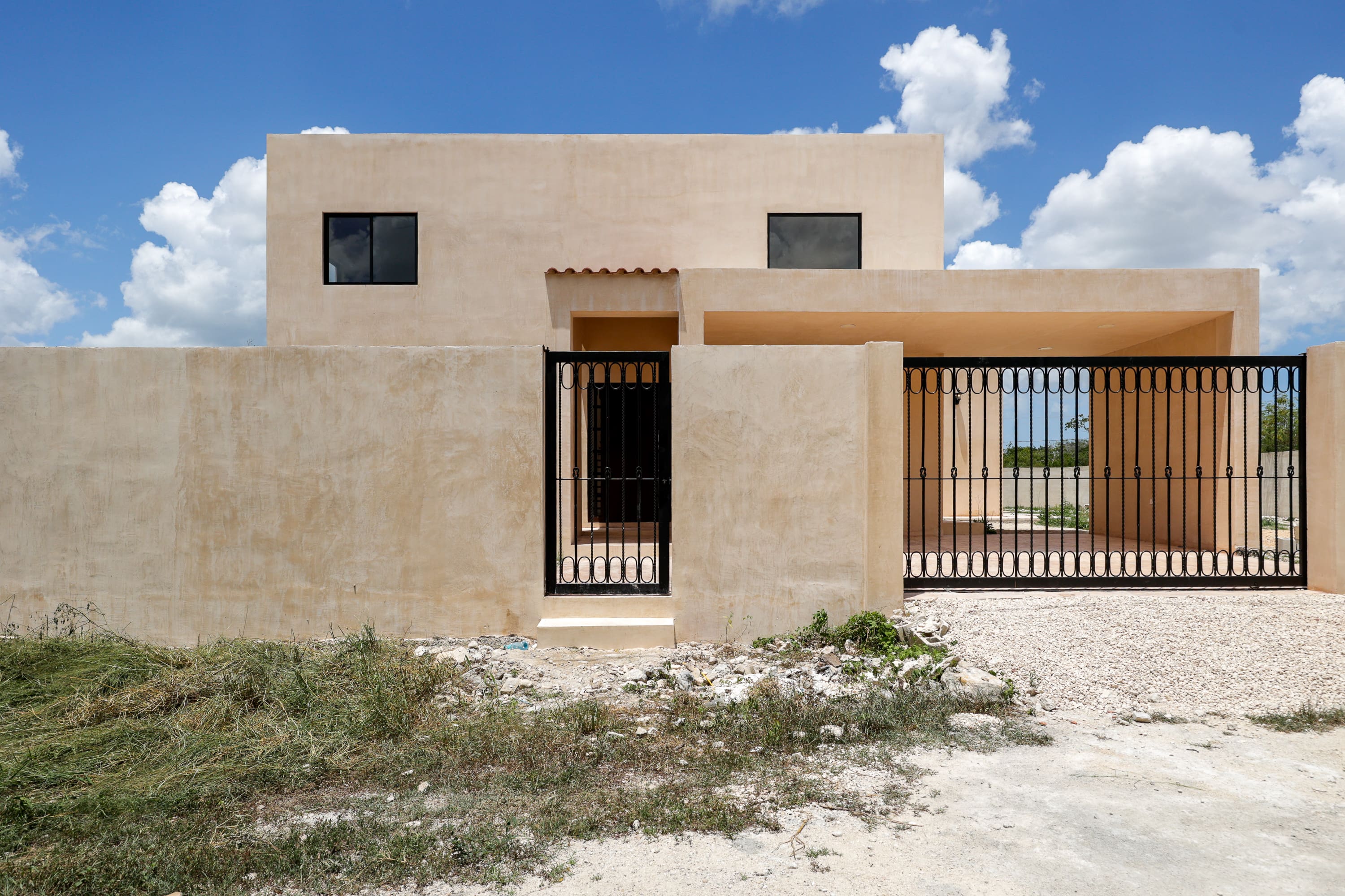 Modern beige stucco house with iron gate