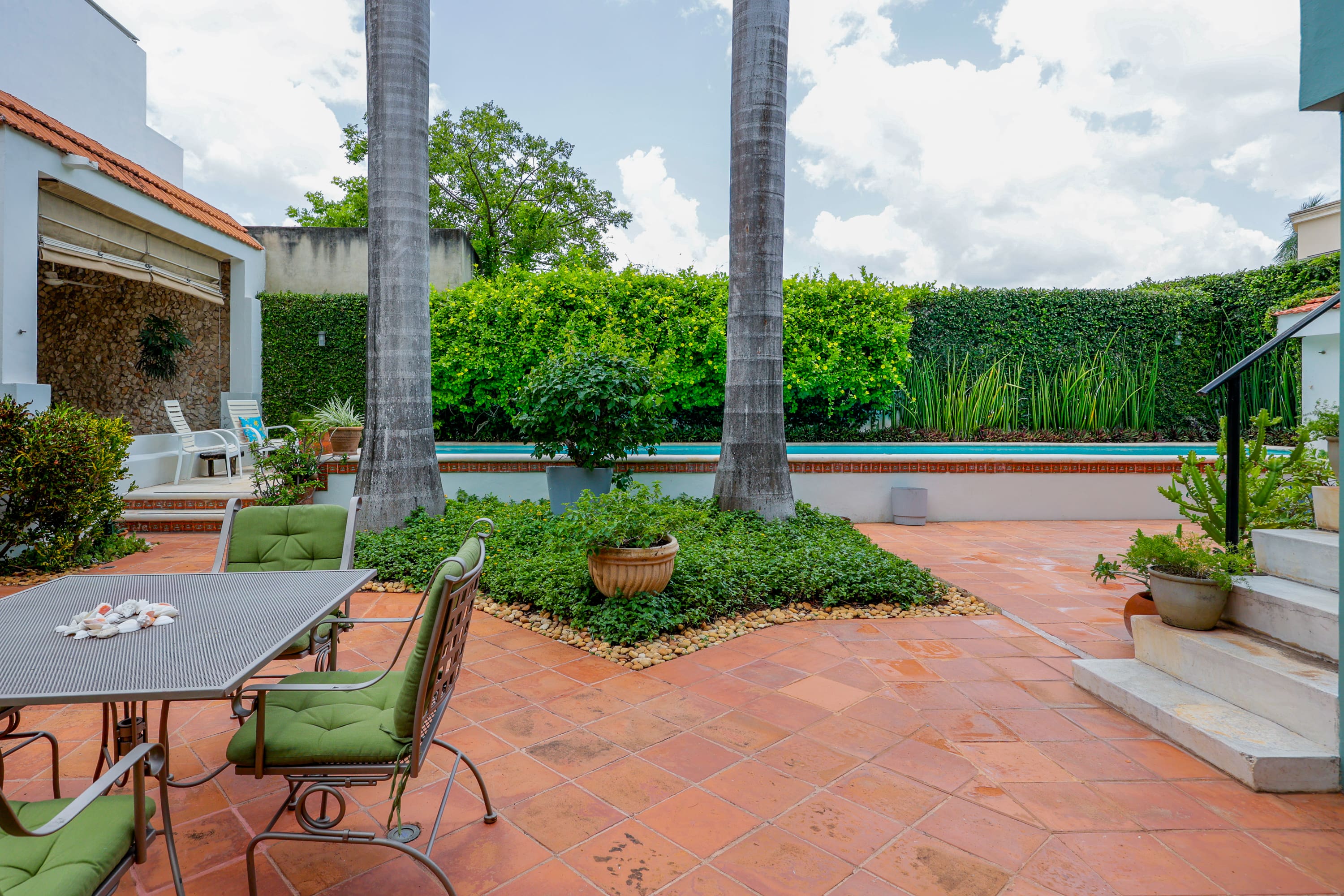 Terracotta patio with dining set and palms