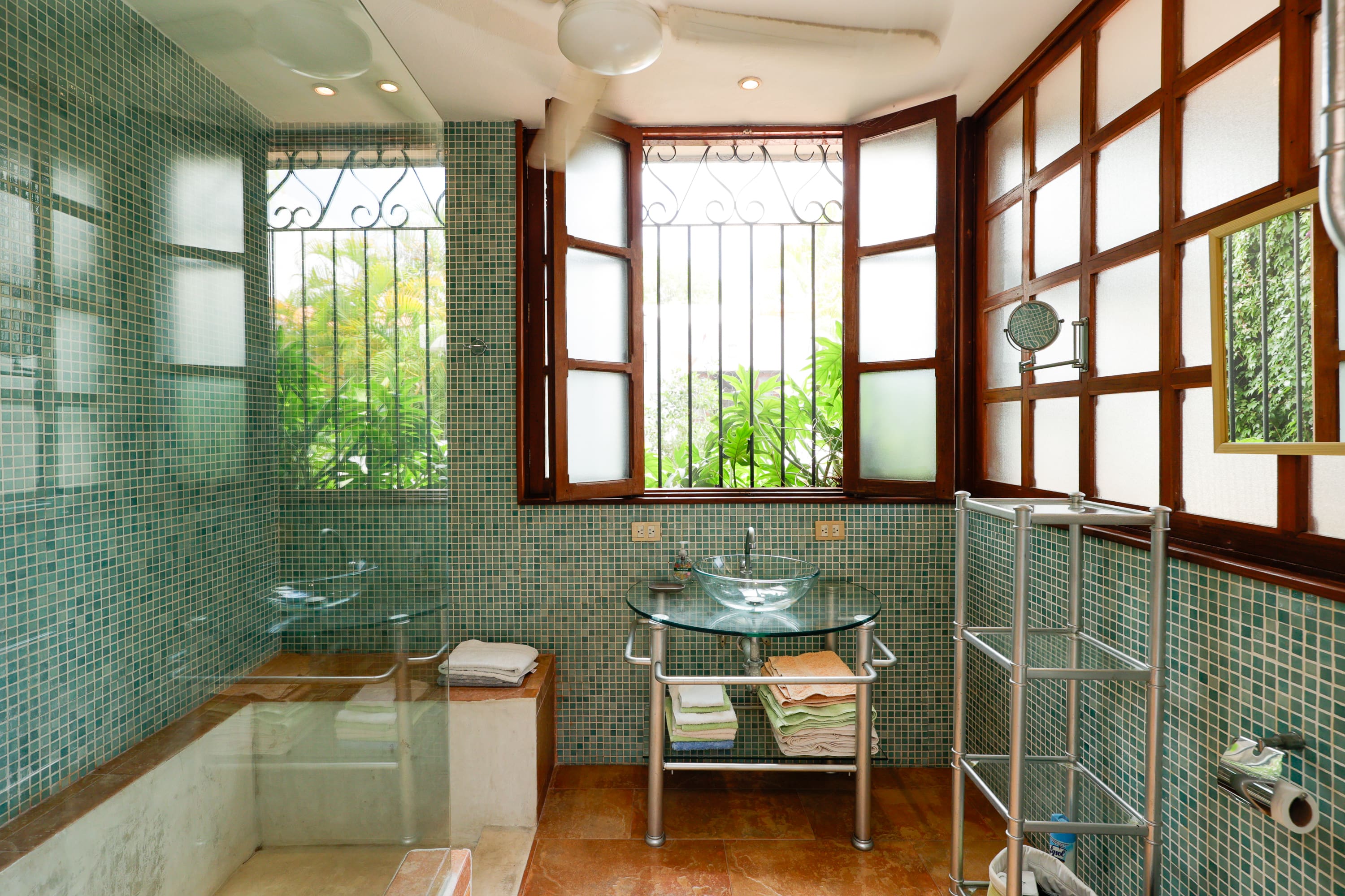 Sunlit bathroom with green mosaic tiles