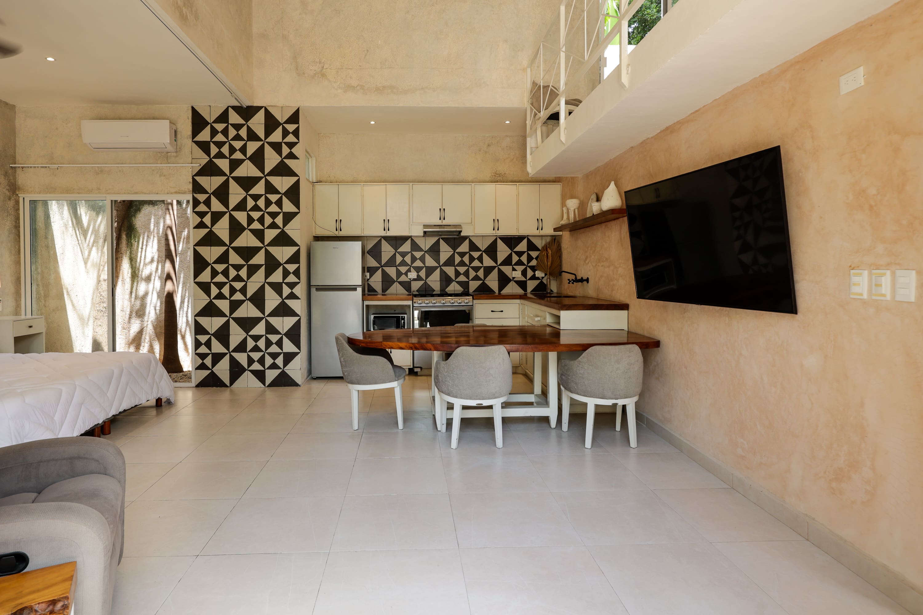 Open-plan studio with patterned kitchen backsplash