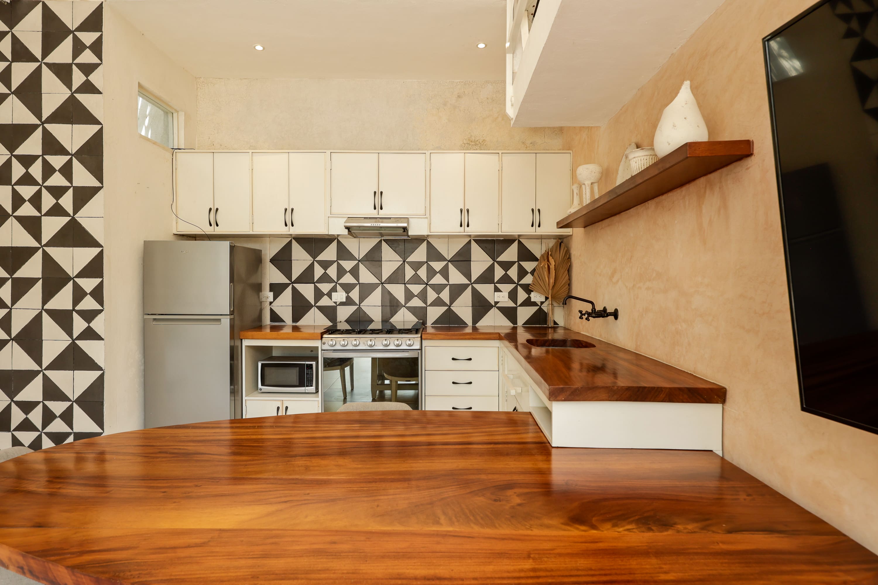 Modern kitchen with wooden counter and geometric backsplash