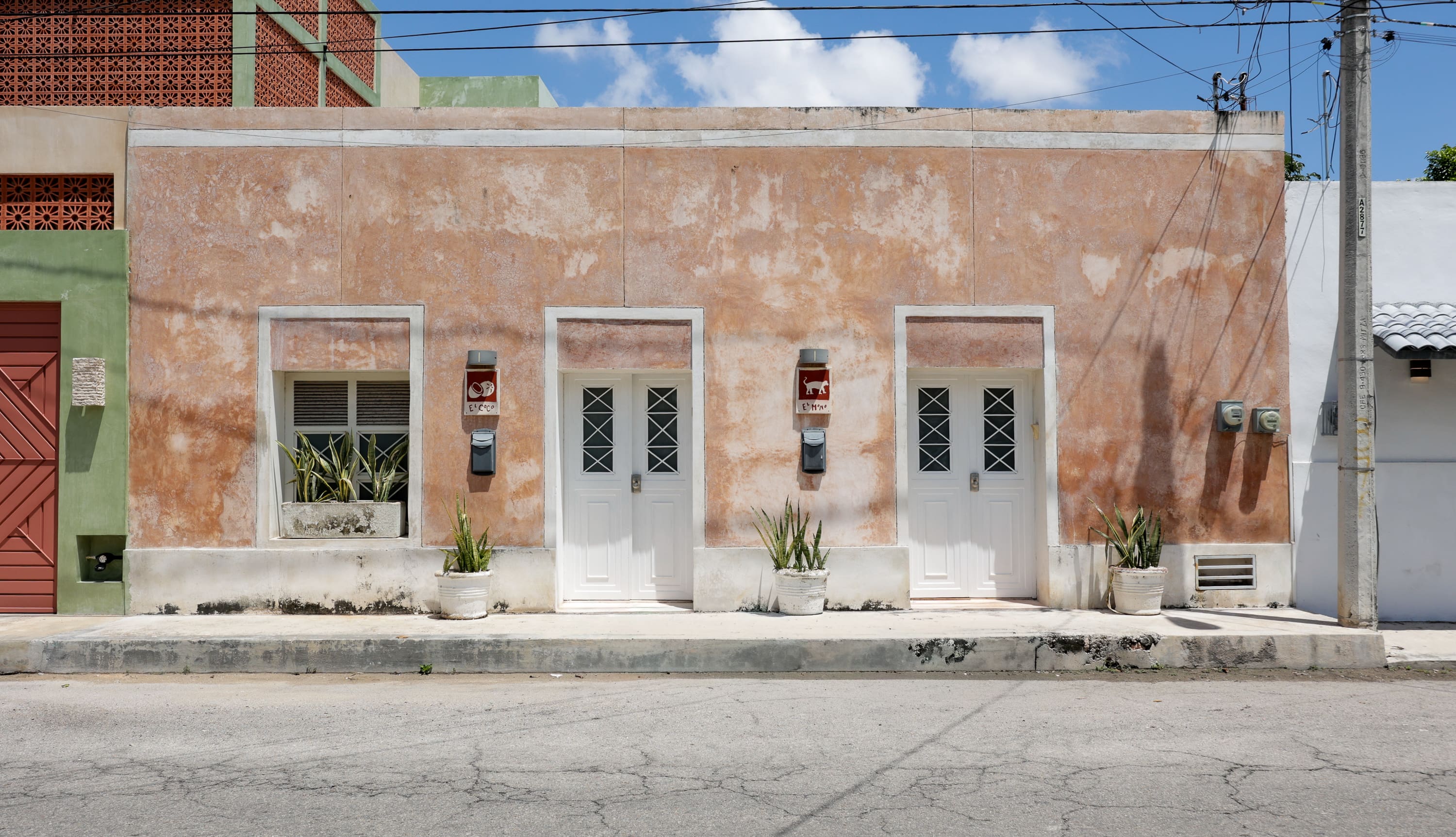 Two white doors on weathered stucco building