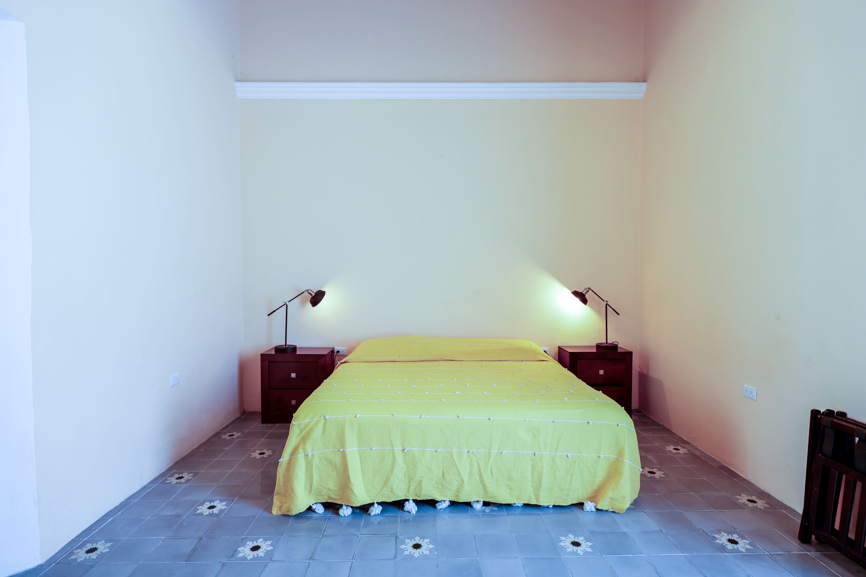 Simple bedroom with yellow bedspread and lamps