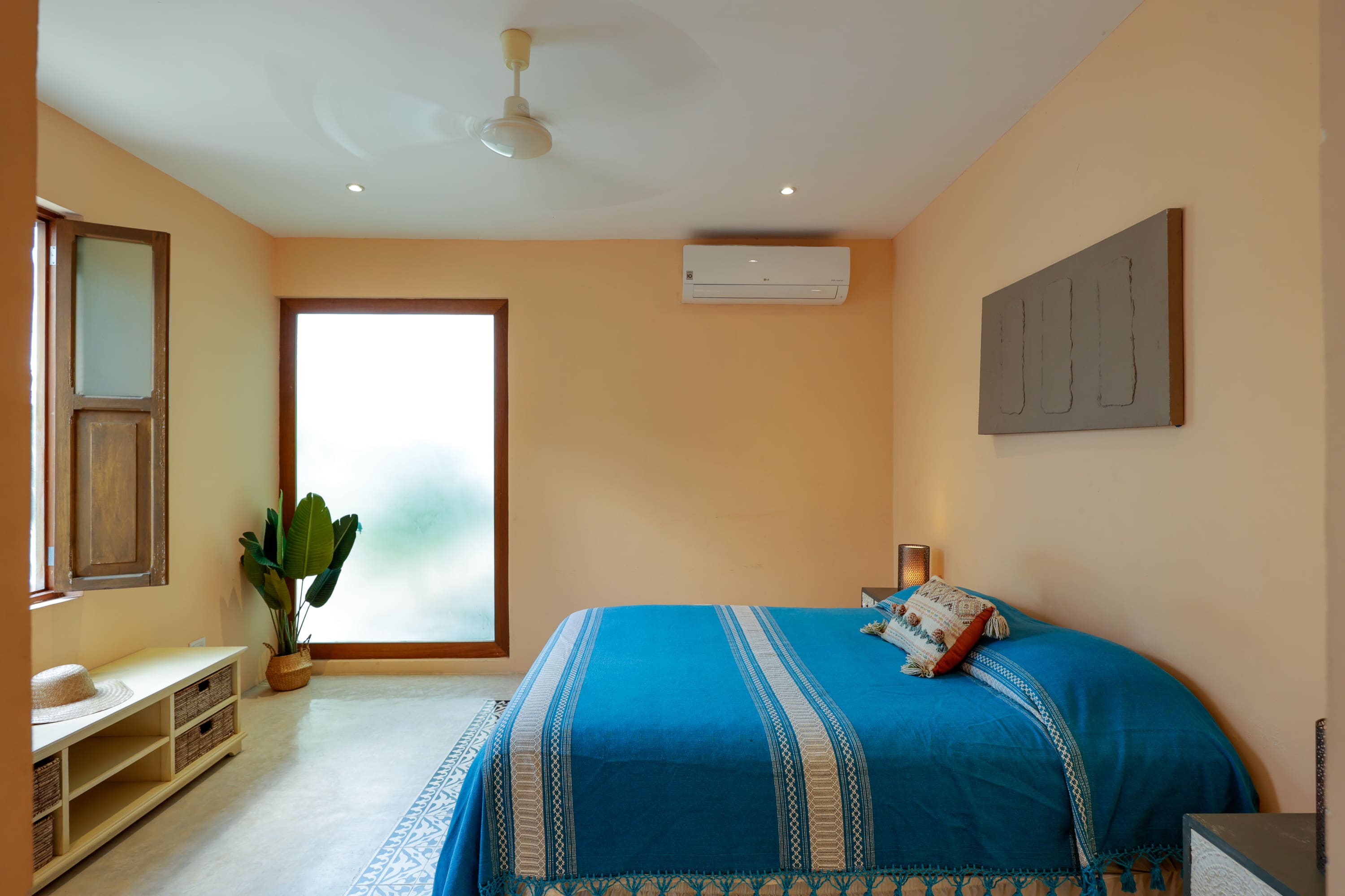 Minimal sunlit bedroom with blue bedspread