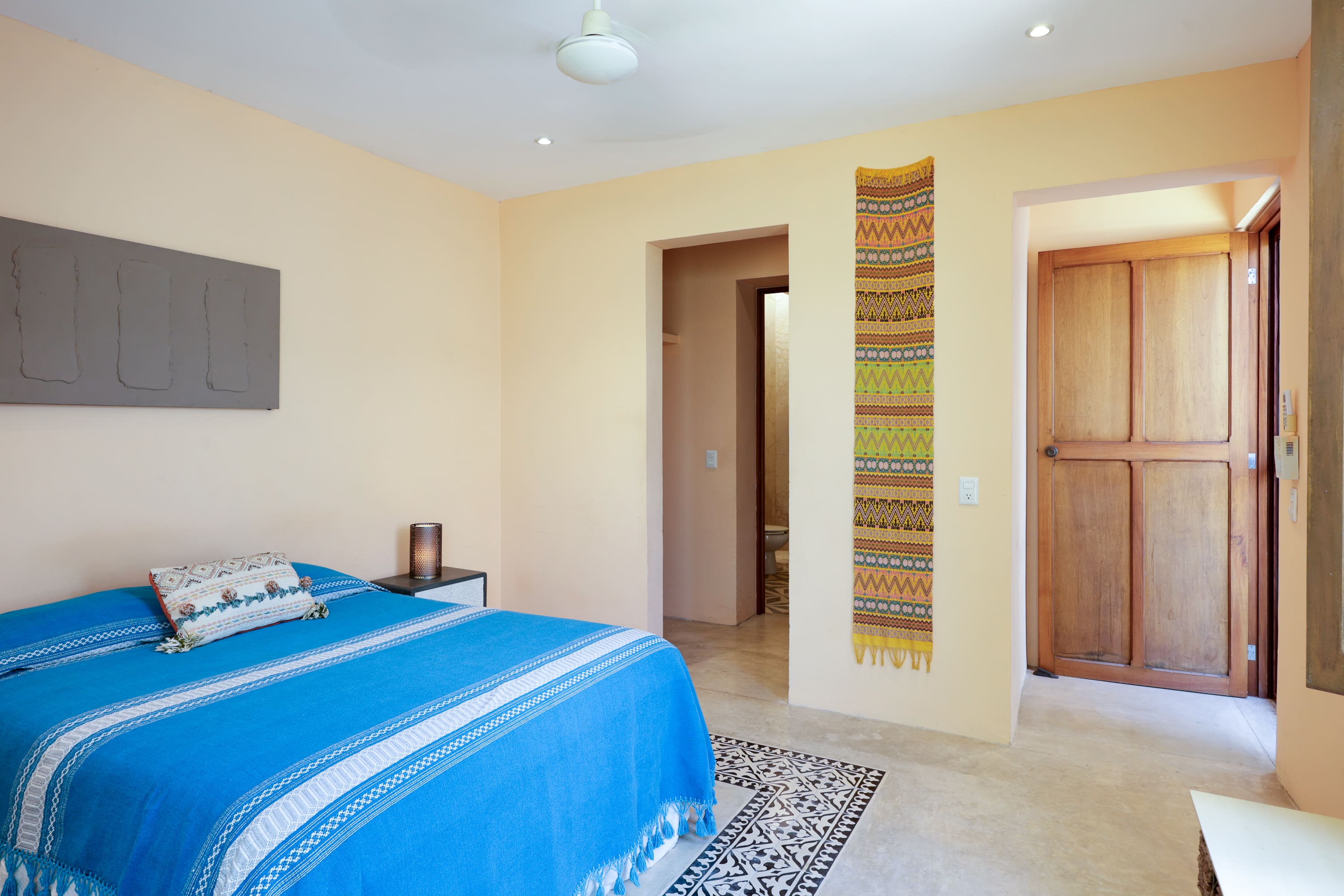 Bright bedroom with blue bedspread and rug