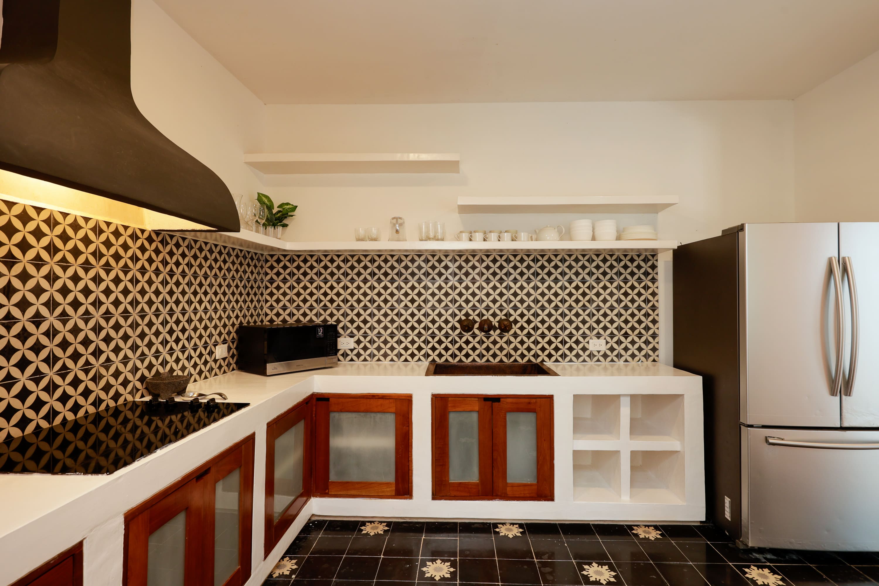 Kitchen with patterned tile backsplash and refrigerator