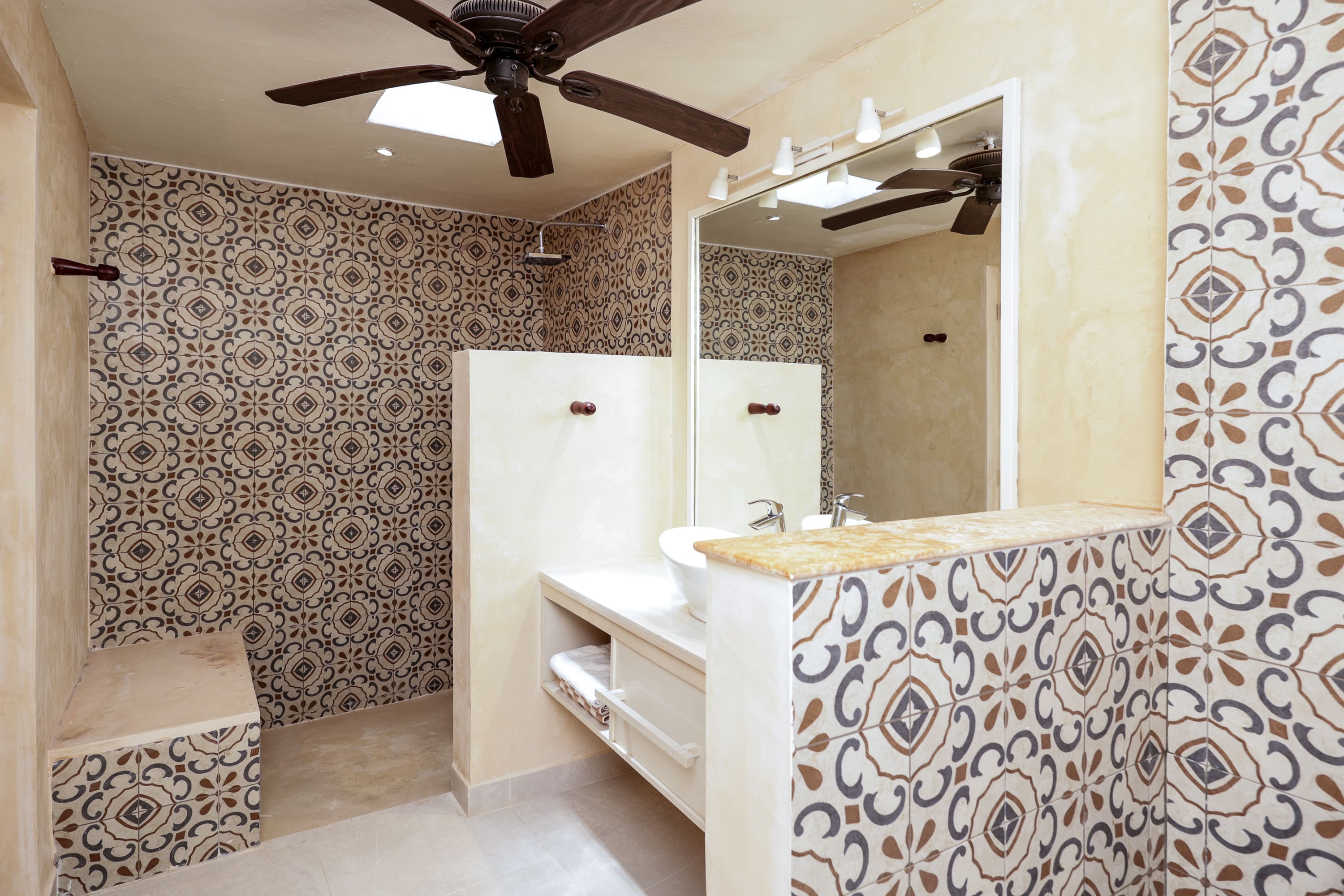 Patterned tiled bathroom with vanity and shower